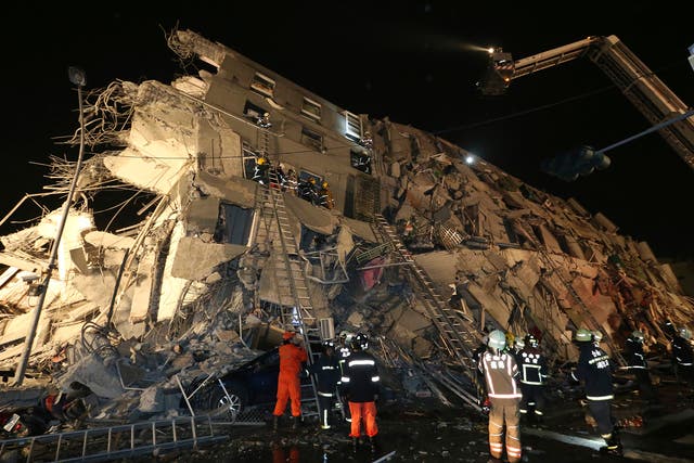 Rescue workers search a toppled building after an earthquake in Tainan, Taiwan