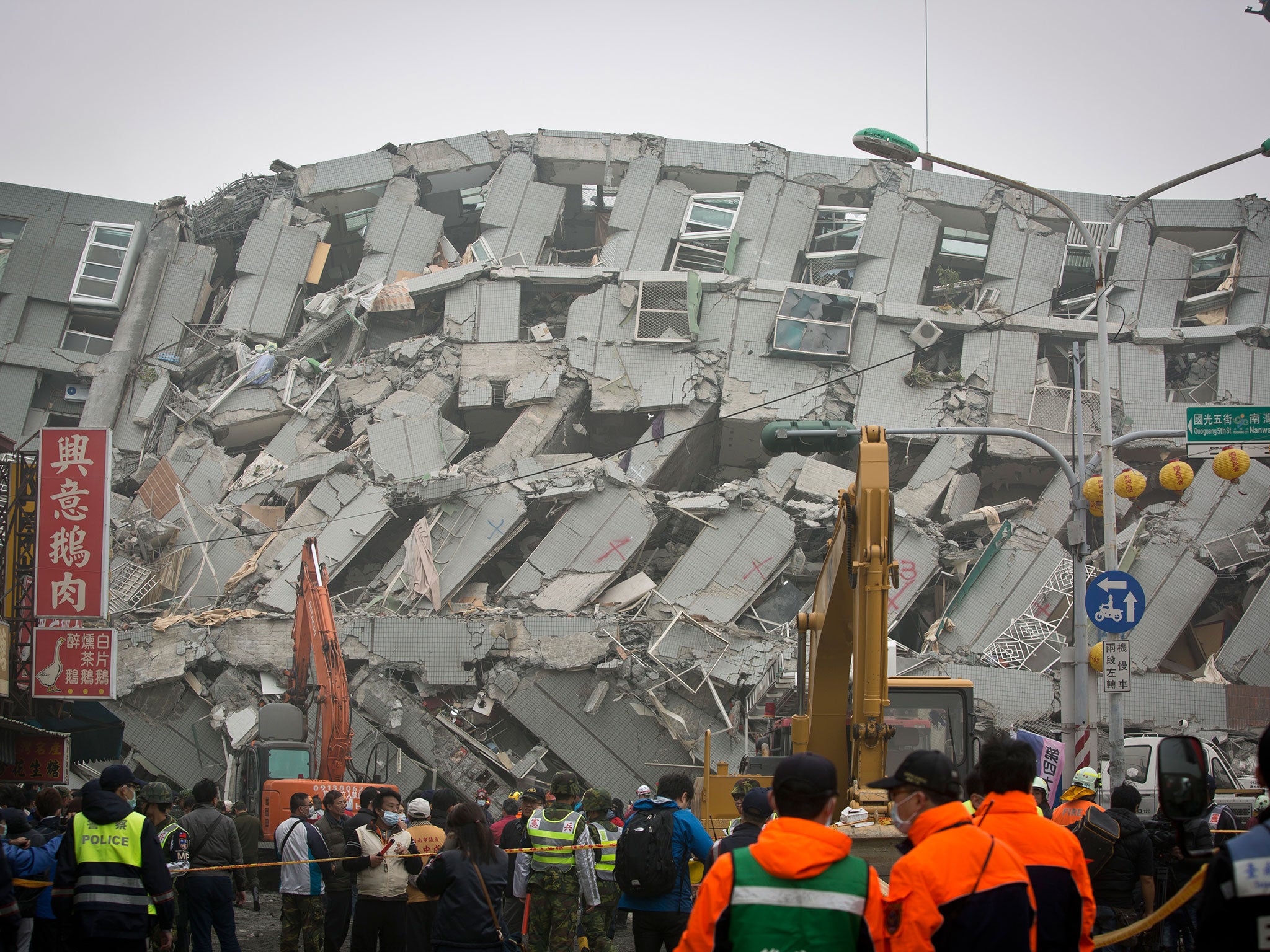 Rescue personnel search for survivors at the site of a collapsed building on 6 February, 2016 in Tainan, Taiwan