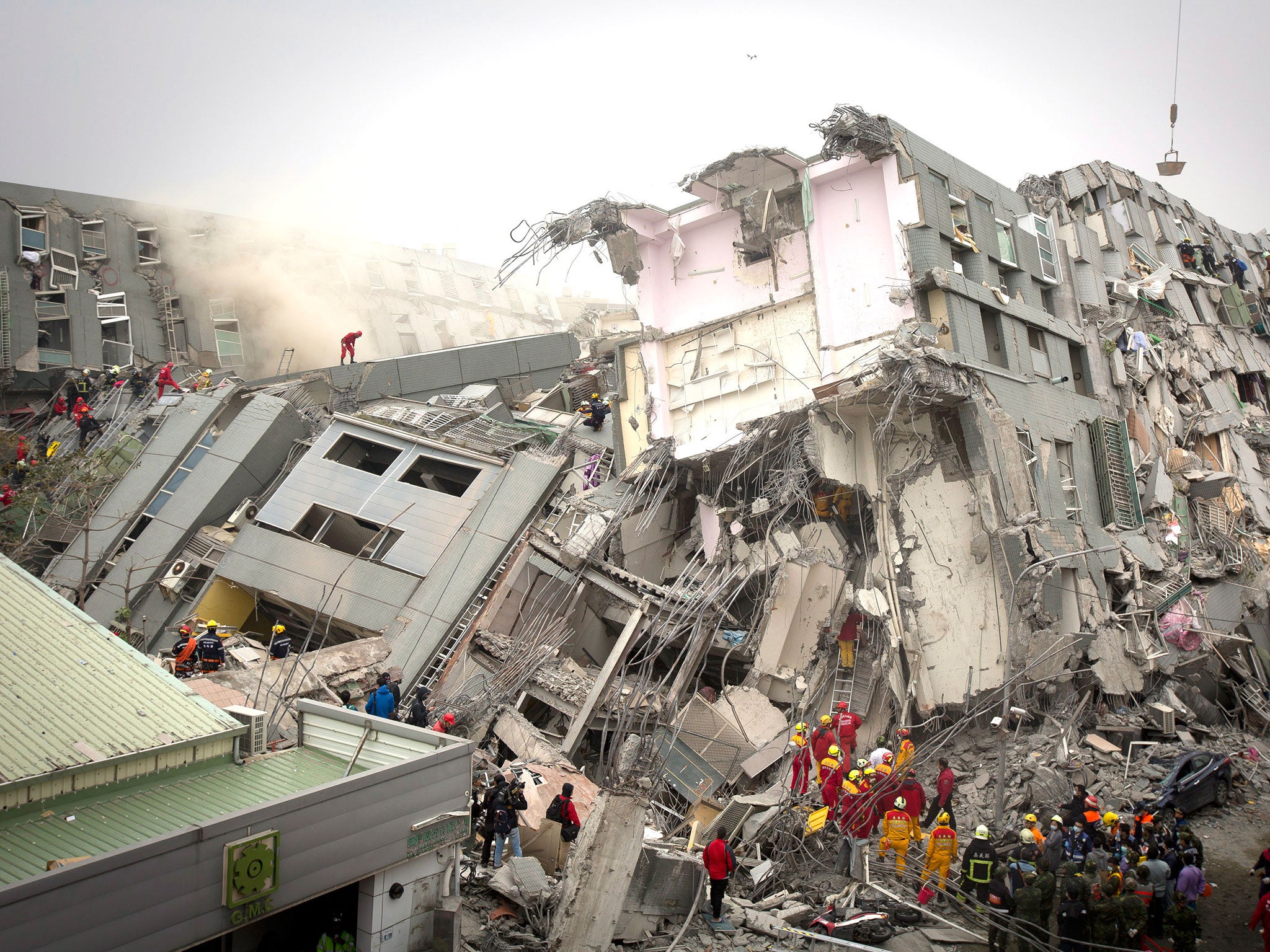 Rescue personnel search for survivors at the site of a collapsed building on 6 February, 2016 in Tainan, Taiwan