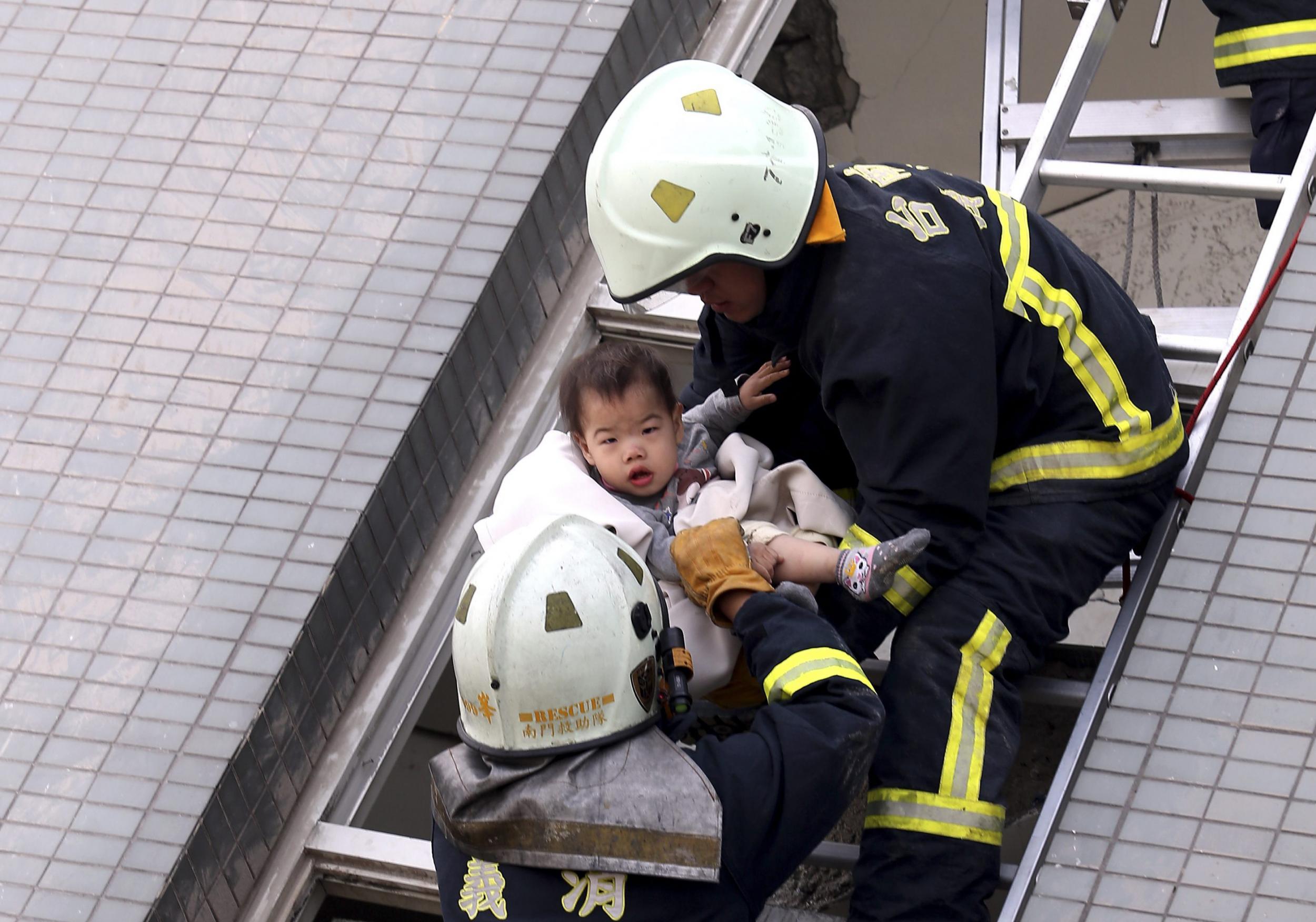 Firefighters rescuing toddler from collapsed building