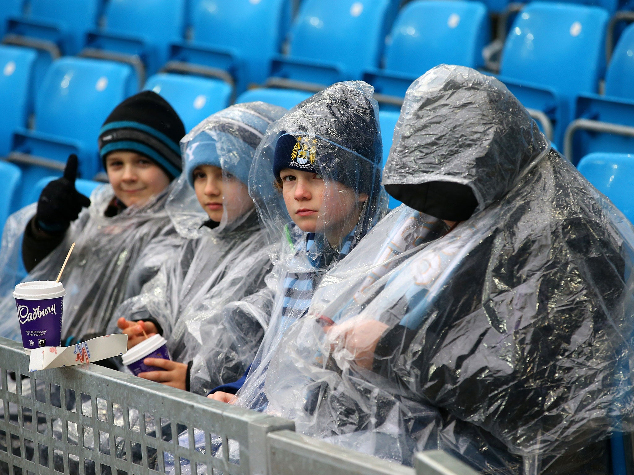 Manchester City fans sit in the stands at the Etihad Stadium ahead of the match against Leicester