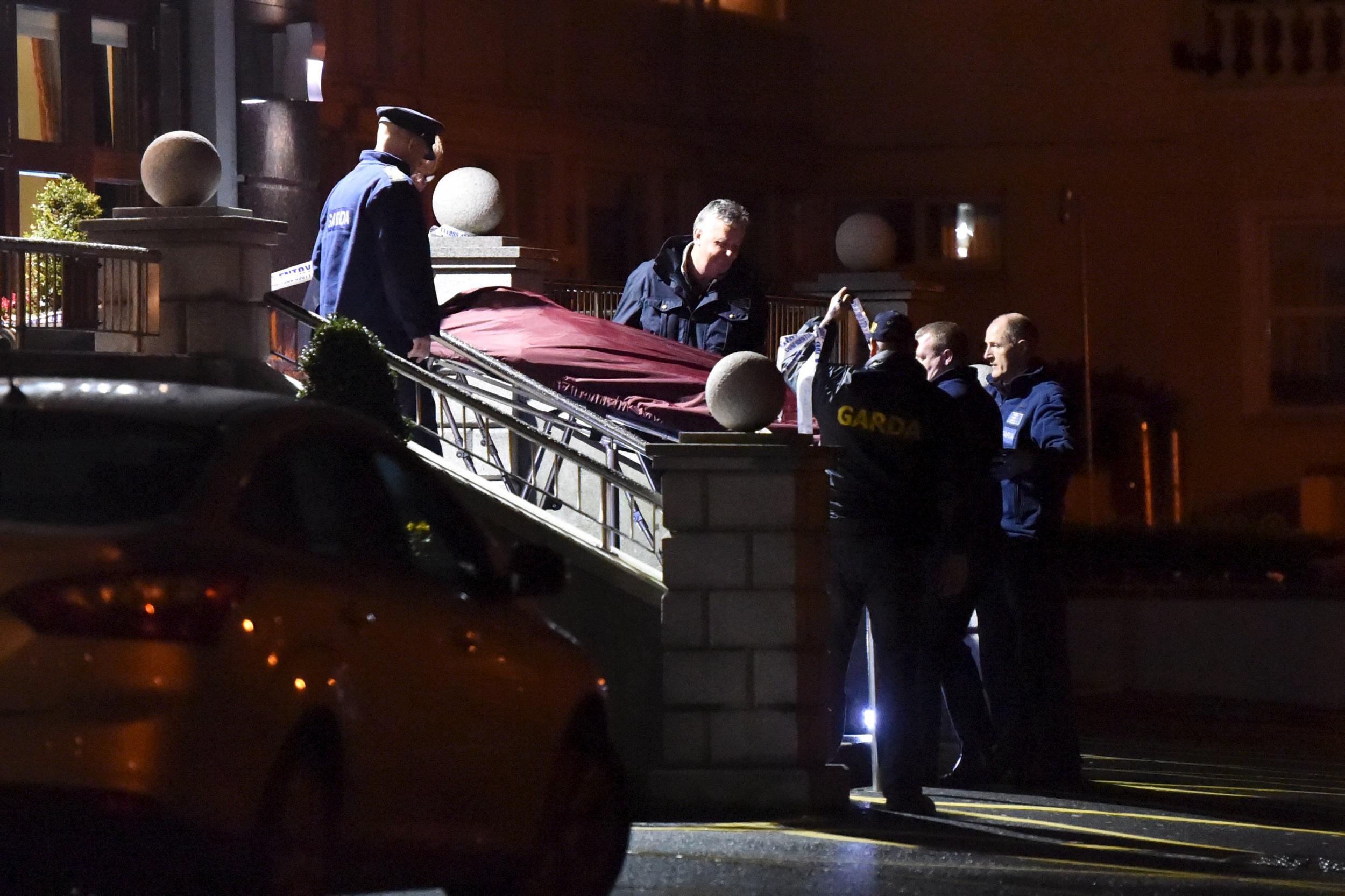 Police remove a body from the scene of a shooting at the Regency Hotel