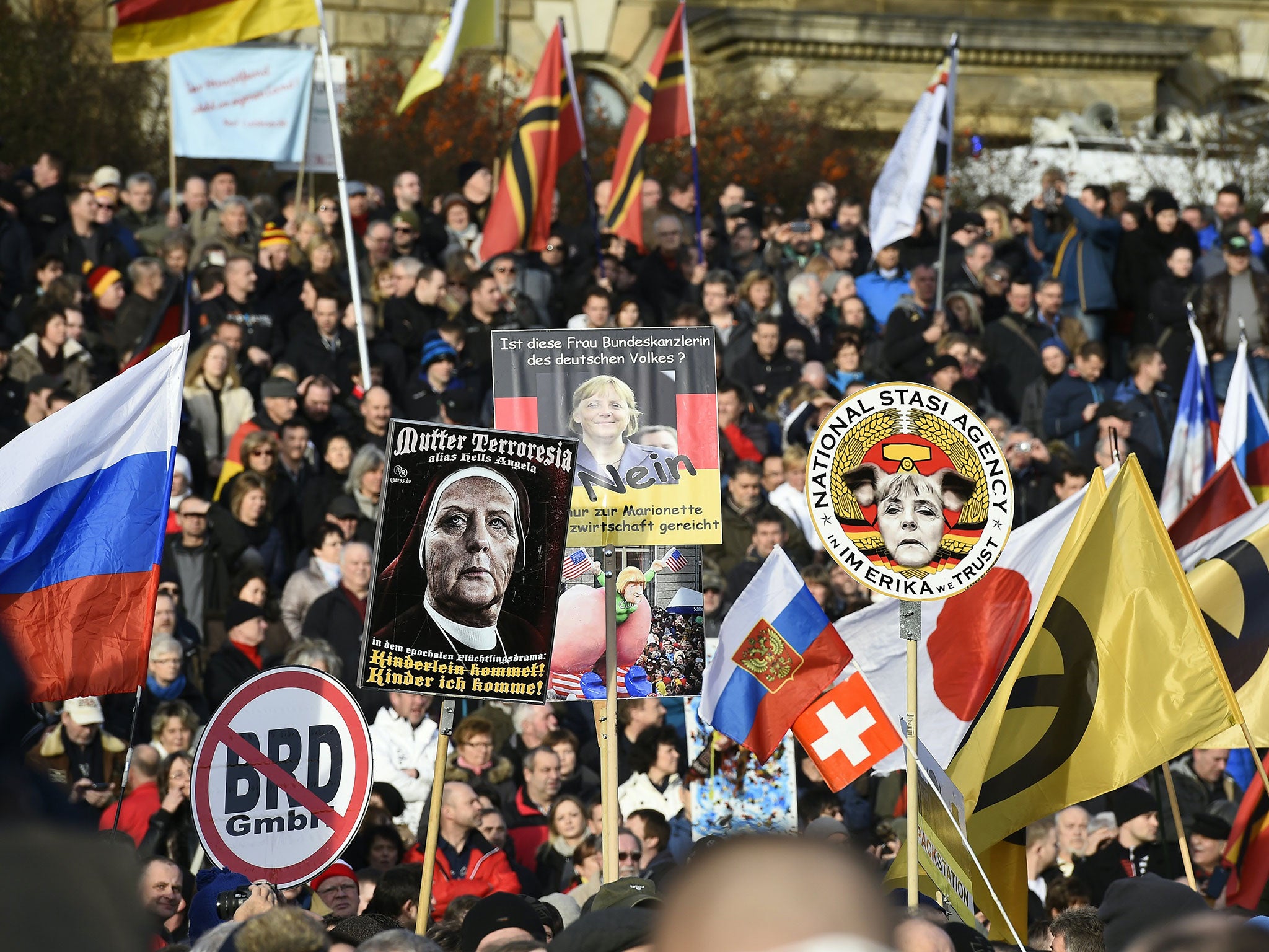 Supporters of the Pegida movement hold placards featuring Angela Merkel in Dresden, eastern Germany, on February 6, 2016