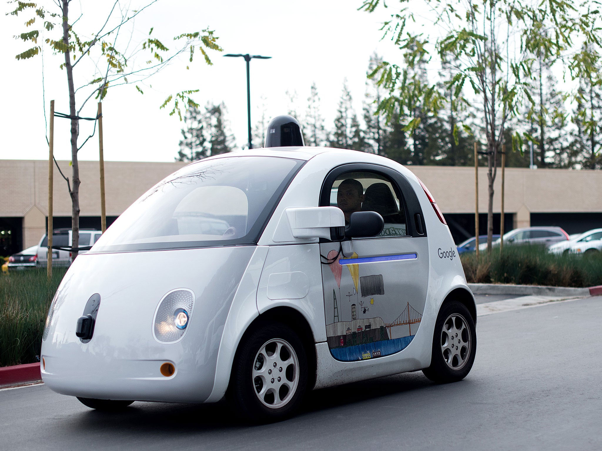 A self-driving car traverses a parking lot at Google's headquarters in Mountain View, California
