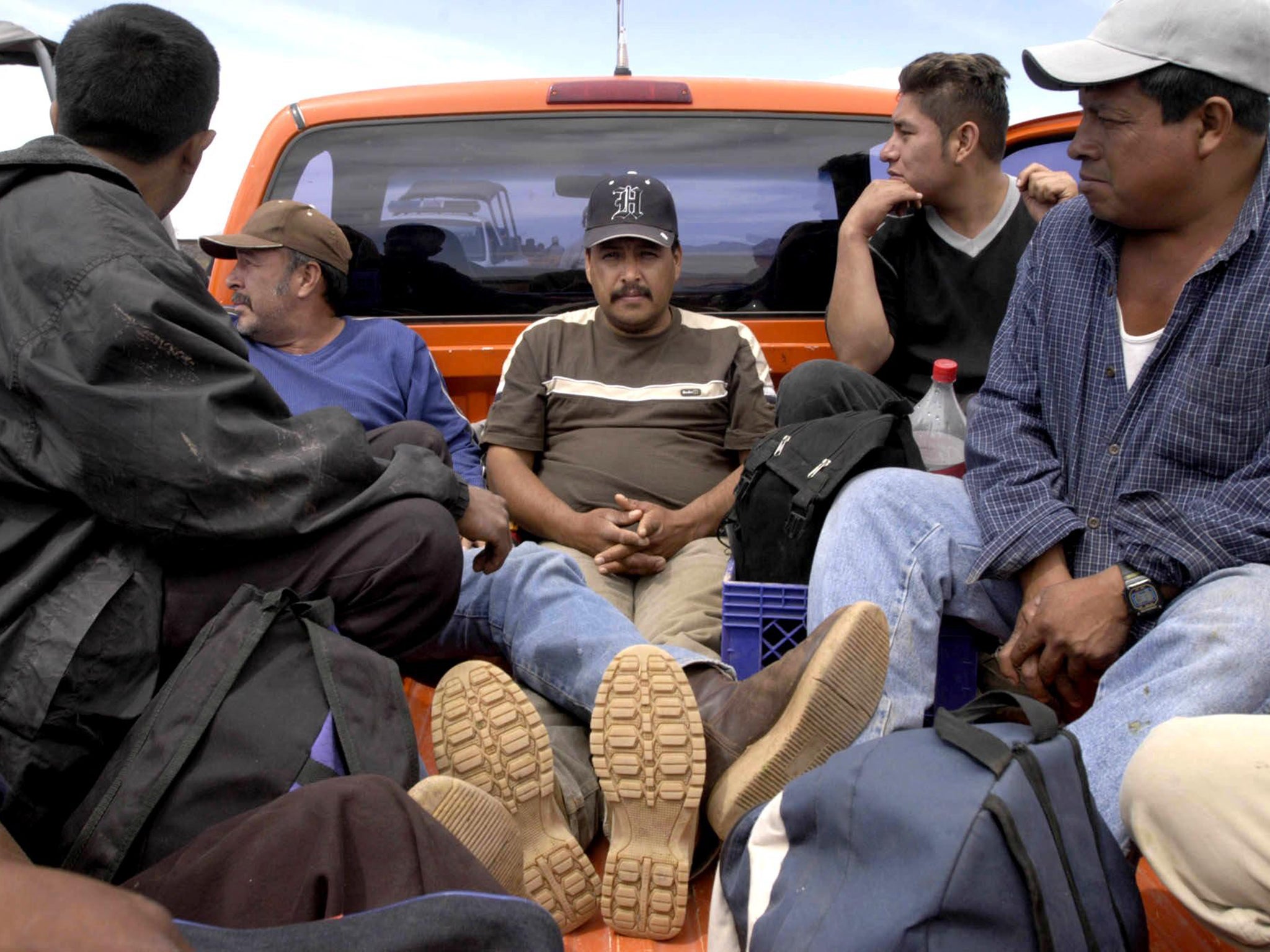 Migrants seeking to cross into the US wait in a pickup truck close to the US-Mexican border in Sonora, Mexico