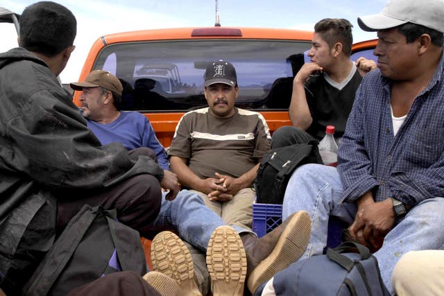Migrants seeking to cross into the US wait in a pickup truck close to the US-Mexican border in Sonora, Mexico