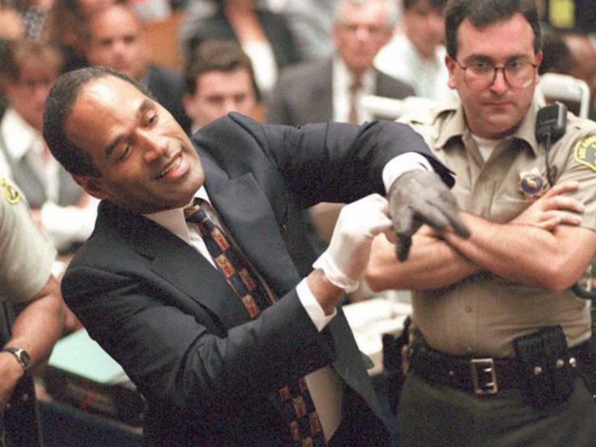 O J Simpson trying on one of the bloody gloves during his murder trial
