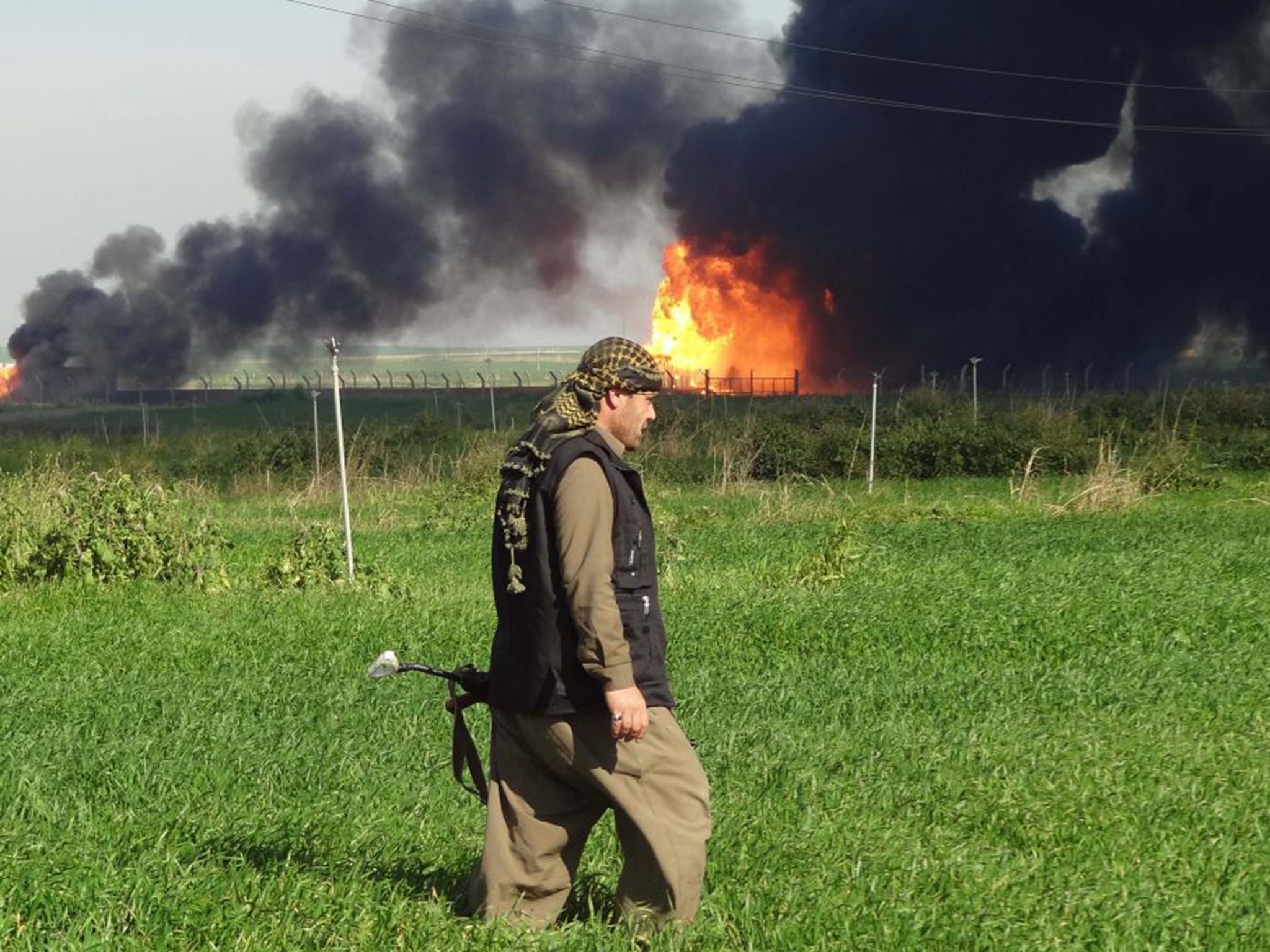 A member of the Kurdish Peshmerga walks at the Khubbaz oil field, west of the city of Kirkuk, after their forces and police retook the area from IS