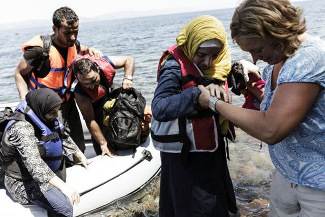 Syrian people arrive on the Greek island of Lesbos after crossing the Aegean sea from Turkey to Greece