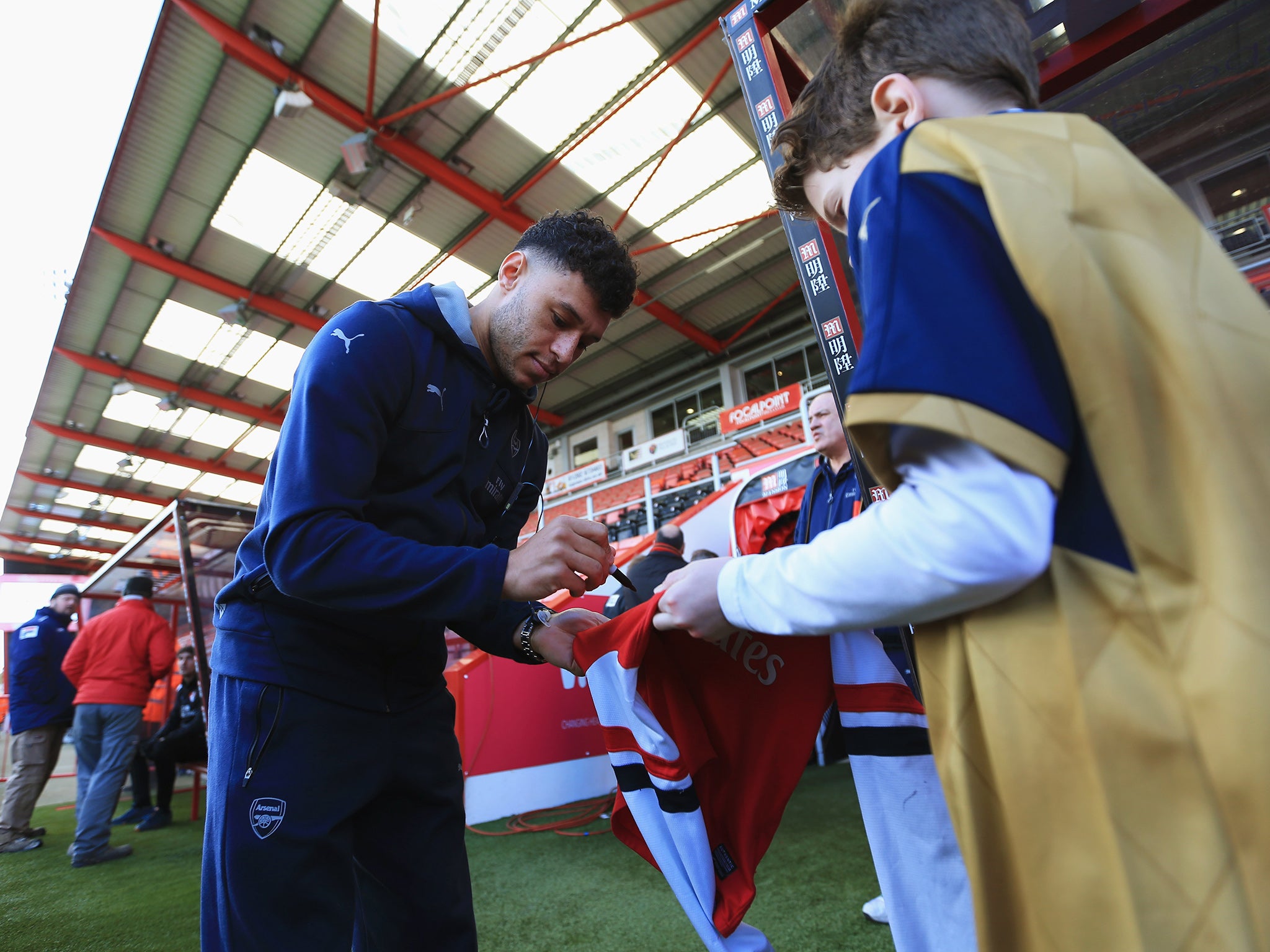 Arsenal winger Alex Oxlade-Chamberlain signs a shirt at the Vitality Stadium