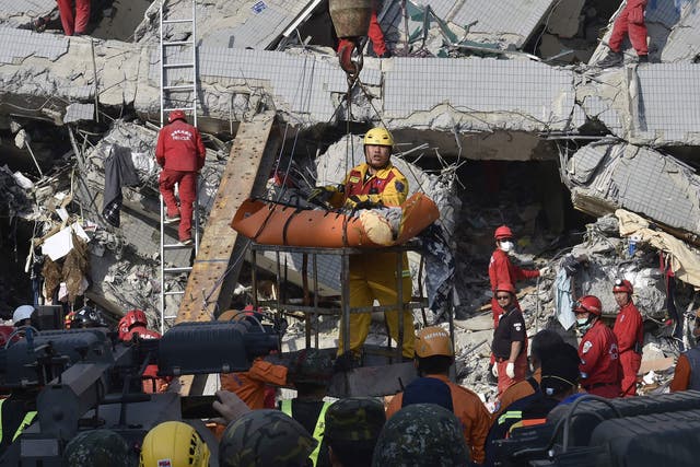A rescue worker carries a victim from the building