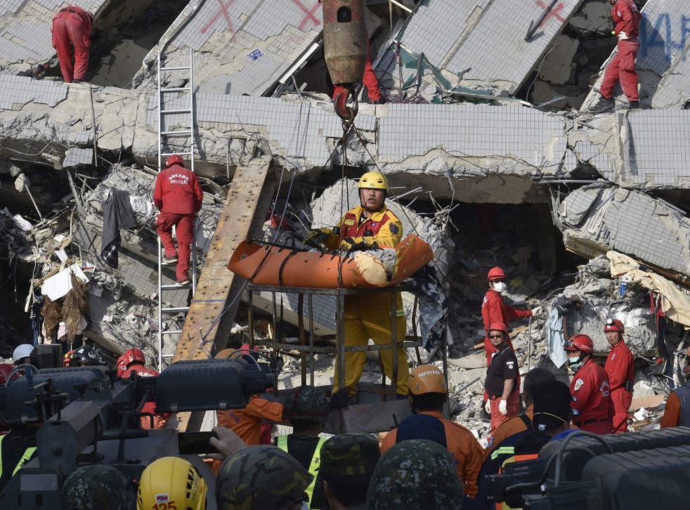 A rescue worker carries a victim from the building