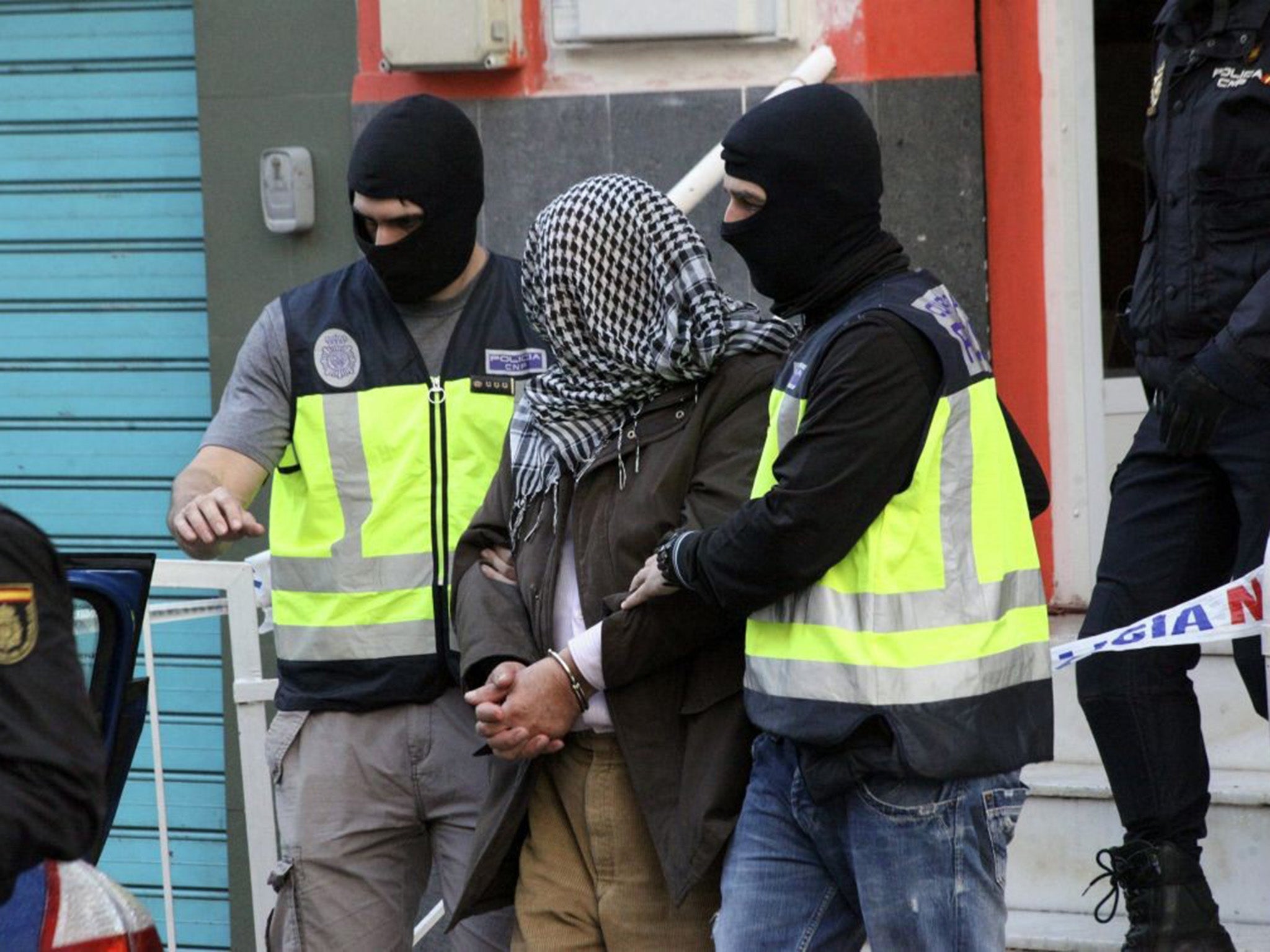 A suspected member of the terror cell is led away by police in Ceuta, Spain's North African enclave