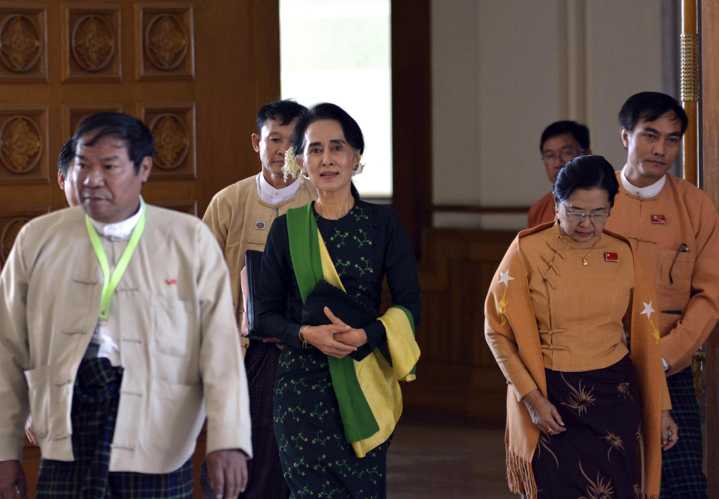 Aung San Suu Kyi walks along with lawmakers of her National League for Democracy (NLD) party