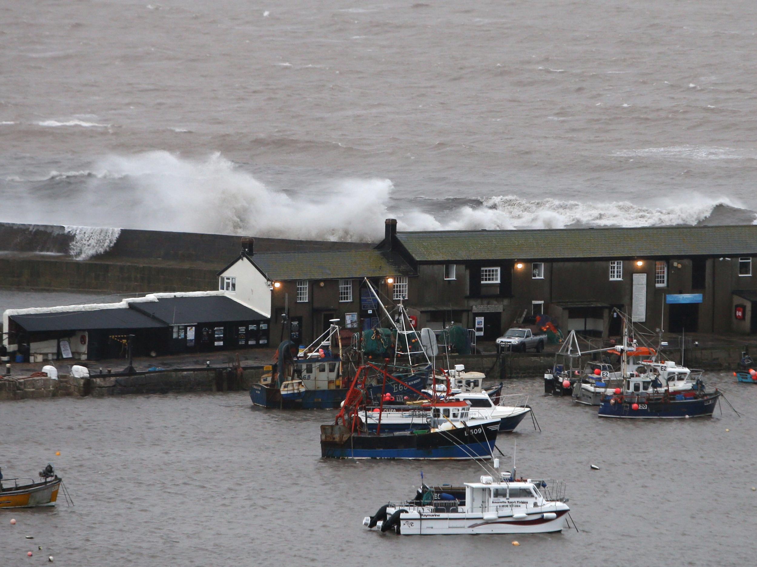 Waves crash against the harbour wall in Lyme Regis, Dorset