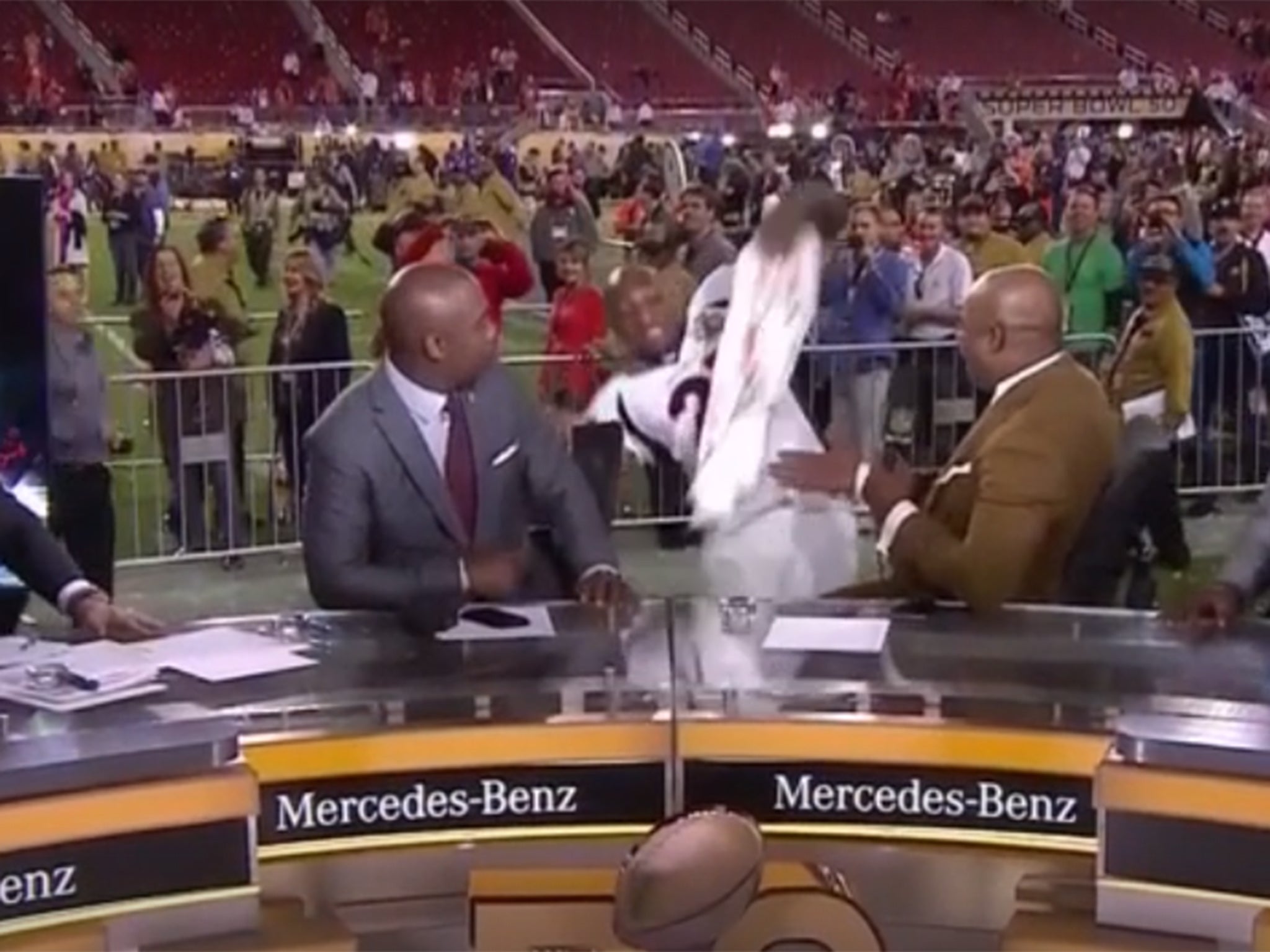 Aqib Talib slips while running over to the NFL Network crew