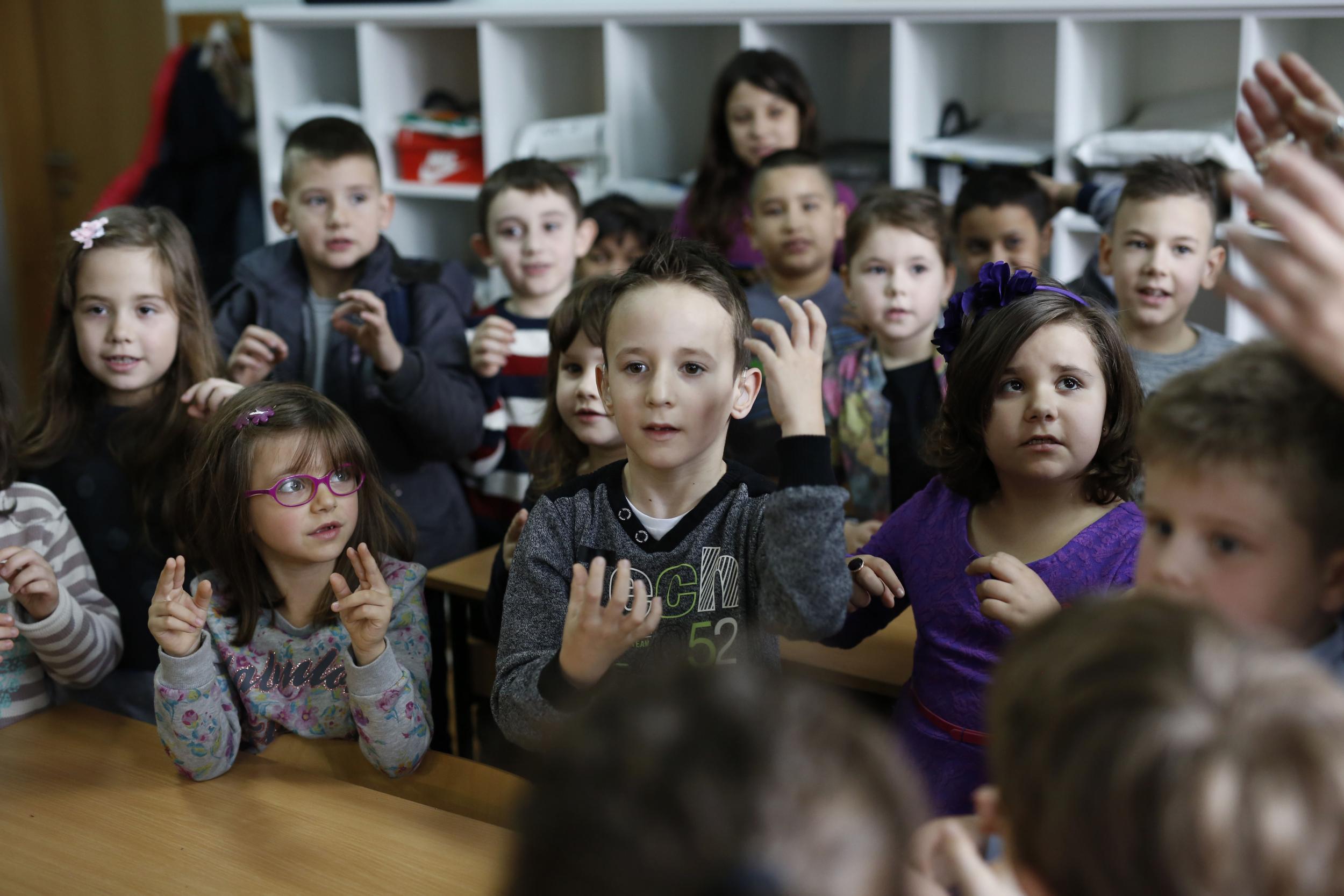 Zejd, centre, is learning sign language with his classmates