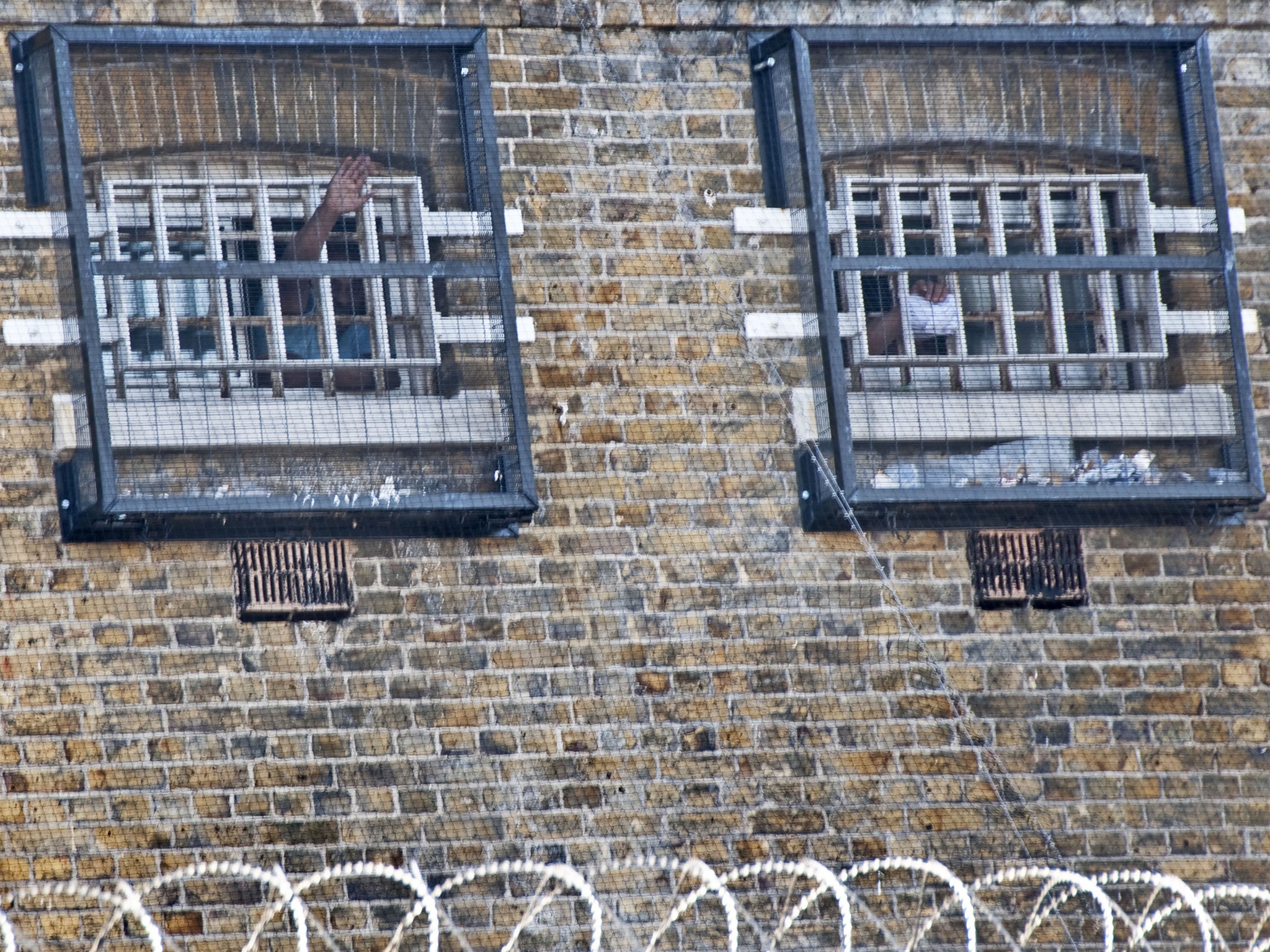 Prisoners waving out their cell window in Brixton prison in South London