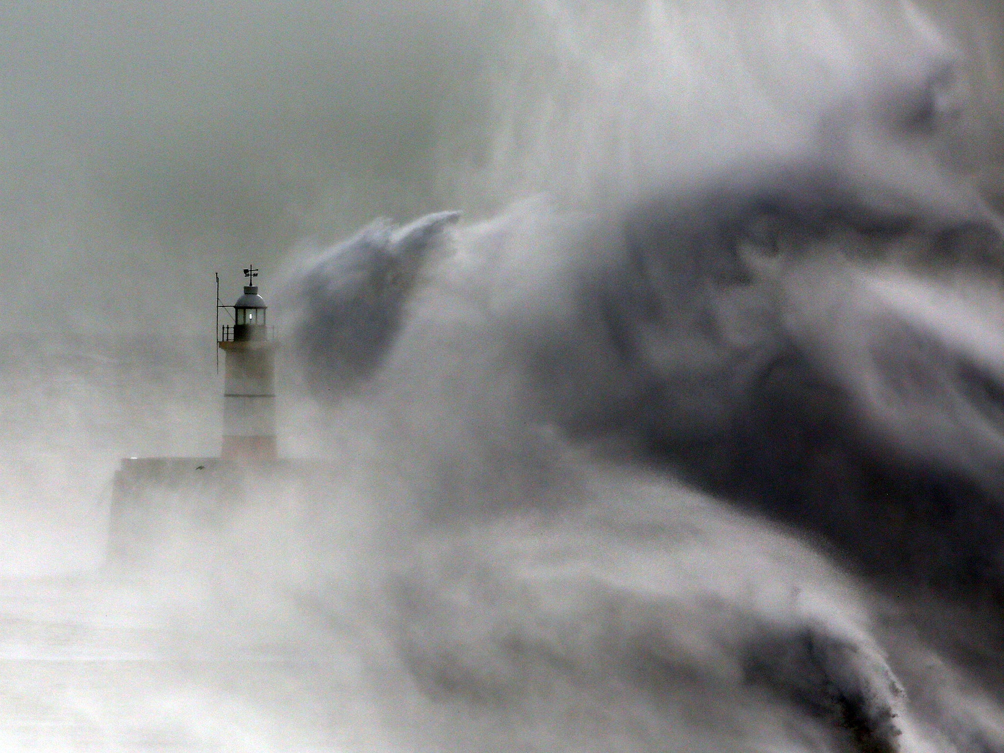 &#13;
Waves hit a lighthouse on the harbour in Newhaven, East Sussex&#13;