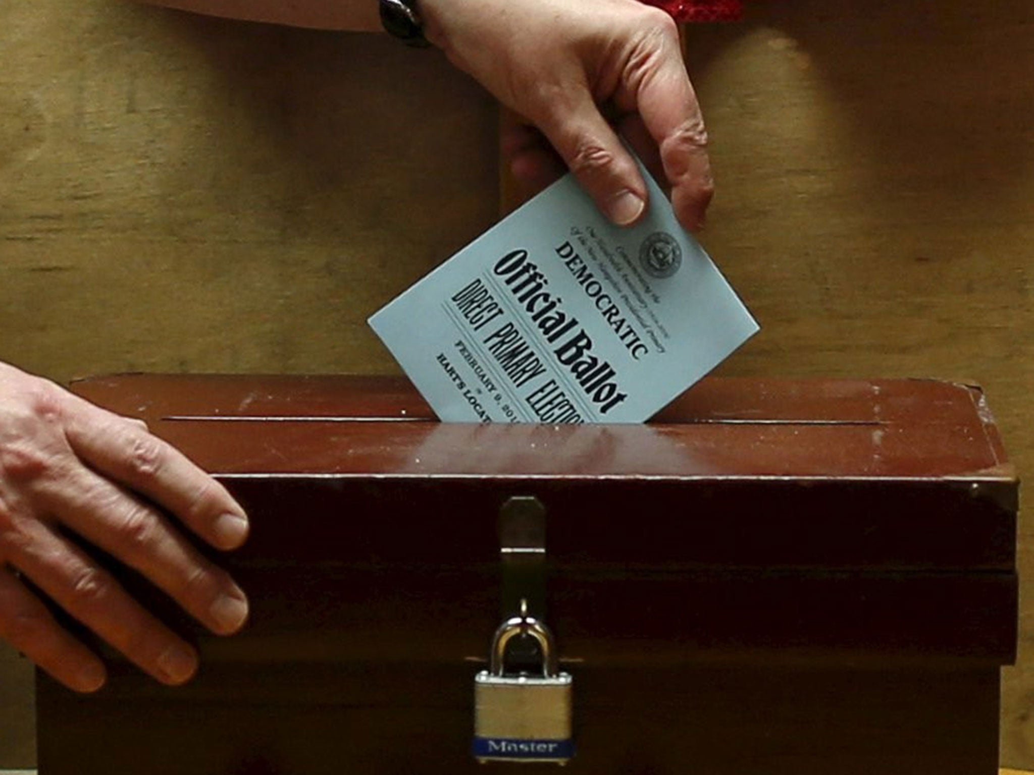 Town moderator Leslie Schoof casts a ballot for a resident in New Hampshire's primary in Hart's Location, New Hampshire, February 9, 2016.