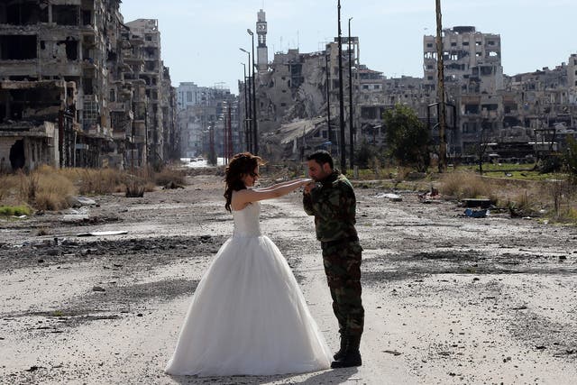 Newlywed Syrian couple Nada Merhi, 18, and Hassan Youssef, 27, pose for a wedding picture amid heavily damaged buildings in the war-ravaged city of Homs.