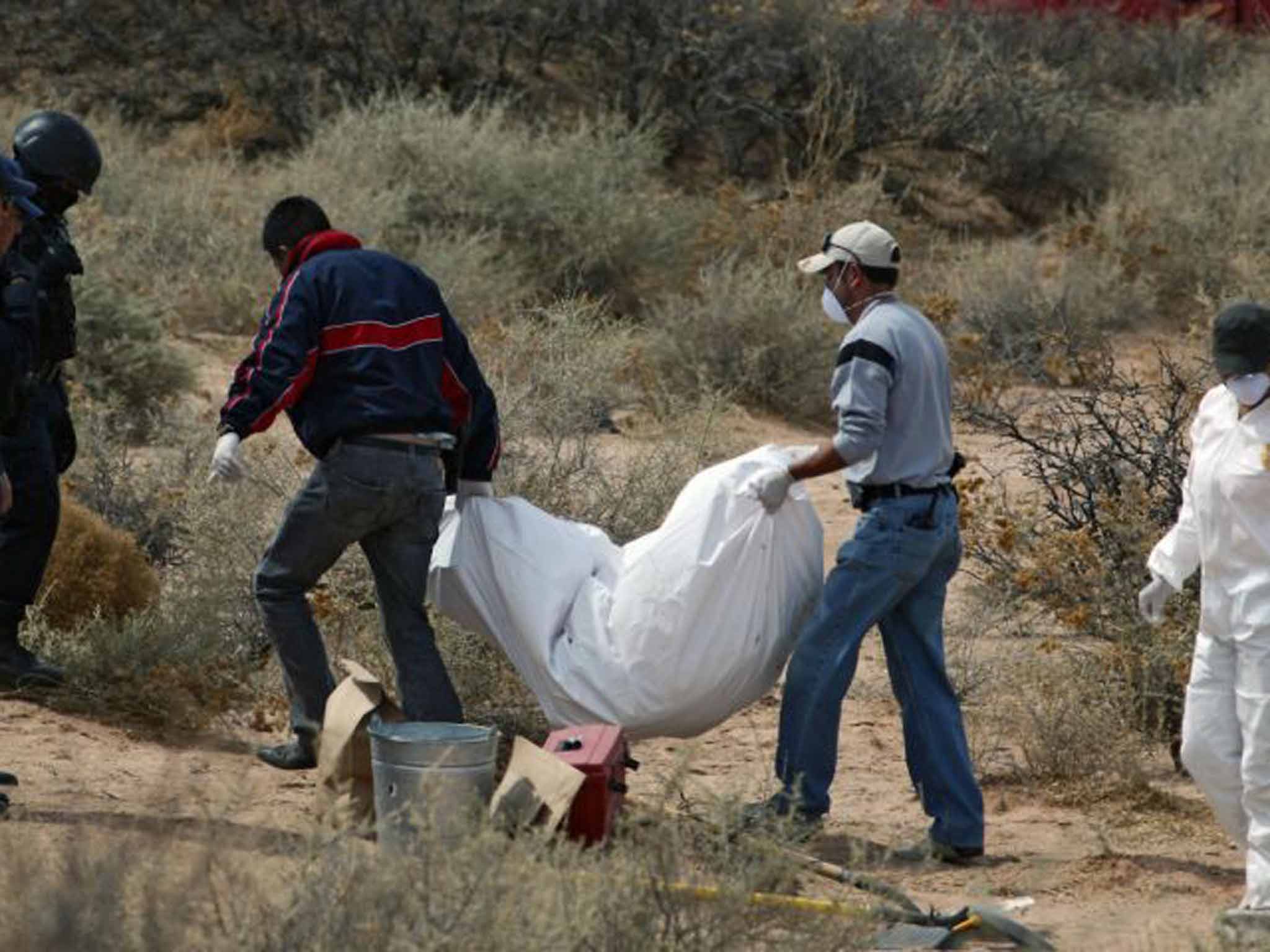 Crime scene: a corpse is removed from the Juarez mass grave