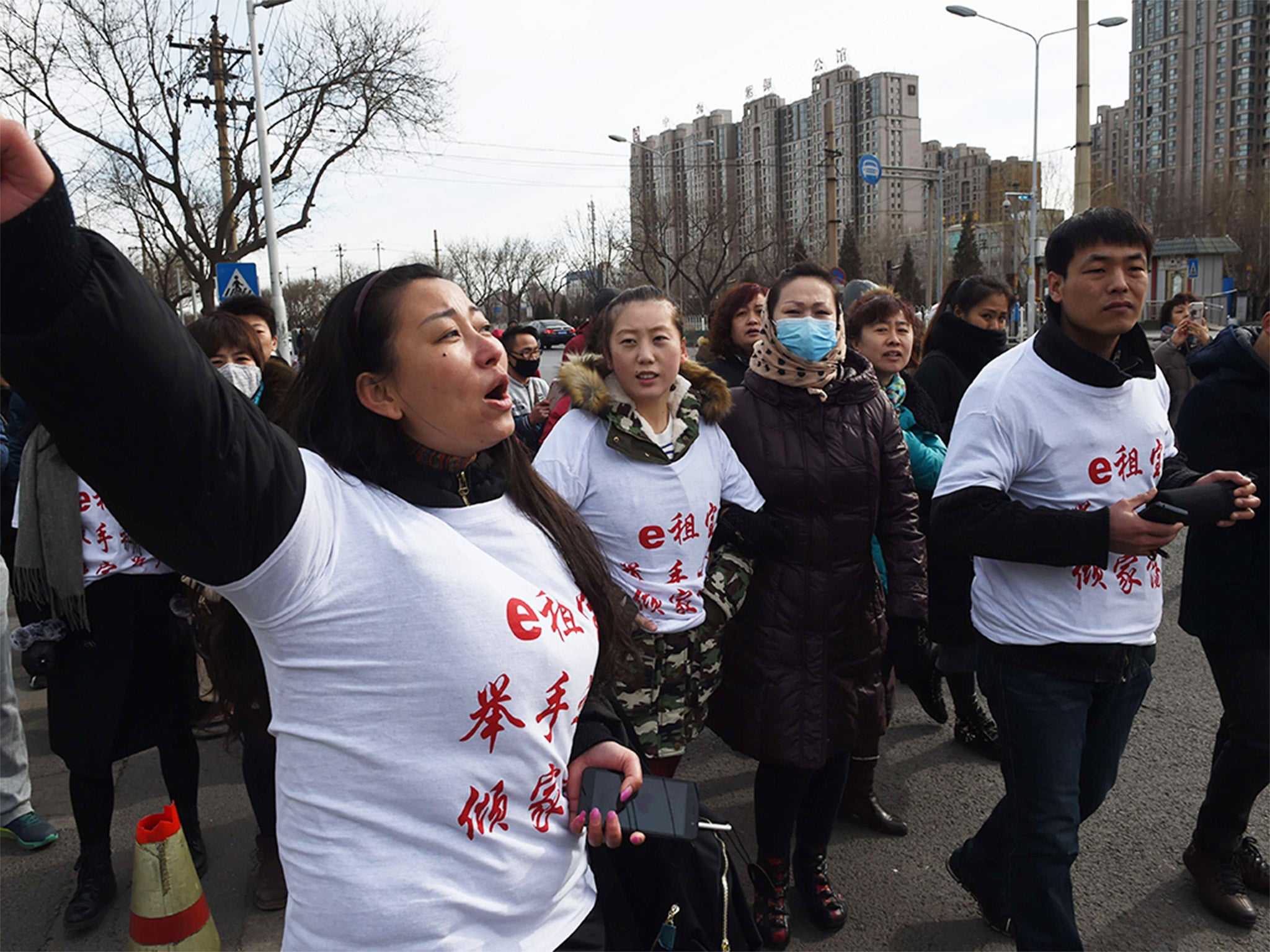 Investors in Ezubo hold a protest in Beijing this week after it was revealed to be a huge fraud. The slogan on their T-shirts reads ‘Ezubo: Raise hands, lose a family fortune