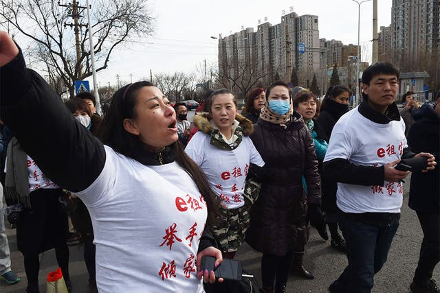 Investors in Ezubo hold a protest in Beijing this week after it was revealed to be a huge fraud. The slogan on their T-shirts reads ‘Ezubo: Raise hands, lose a family fortune