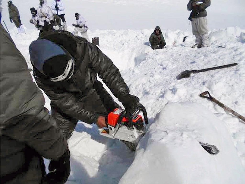 Indian army personnel cut through ice as they search for survivors