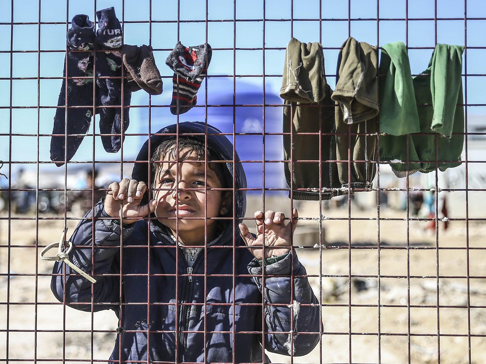 Syrians who have fled the attacks congregate at the Bab al-Salama crossing on the Turkish-Syrian border (Getty)