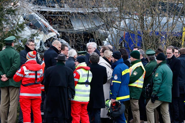Bavarian state governor Horst Seehofer, center, arrives at the site where two trains collided head-on near Bad Aibling, Germany