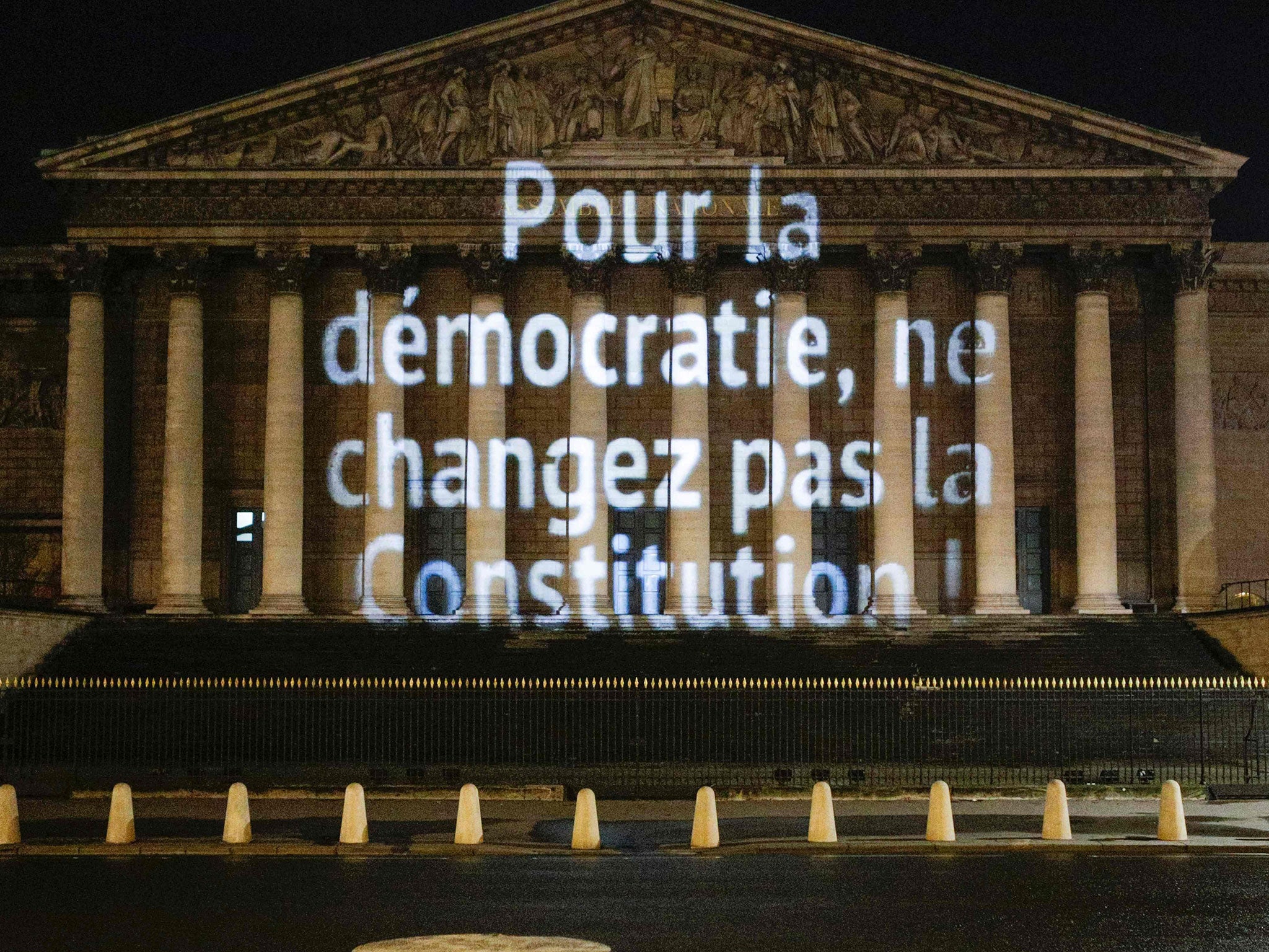 A message reading 'In the name of democracy, do not change the constitution!' on the walls of the French National Assembly building on the night before the 10 February vote.