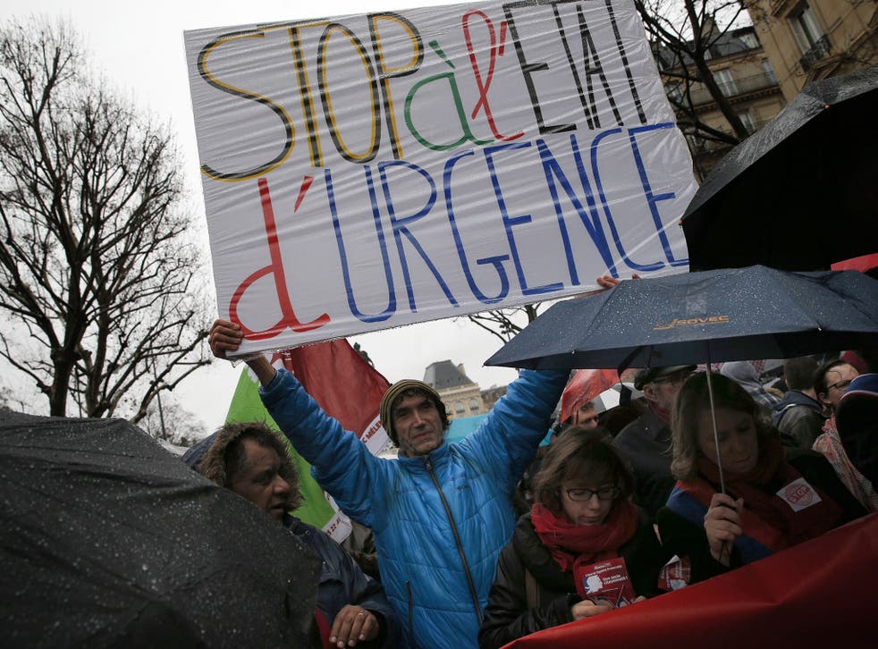 A protester holds a banner reading: " Stop of state of emergency" during a protest, in Paris, Saturday, Jan. 30, 2016.