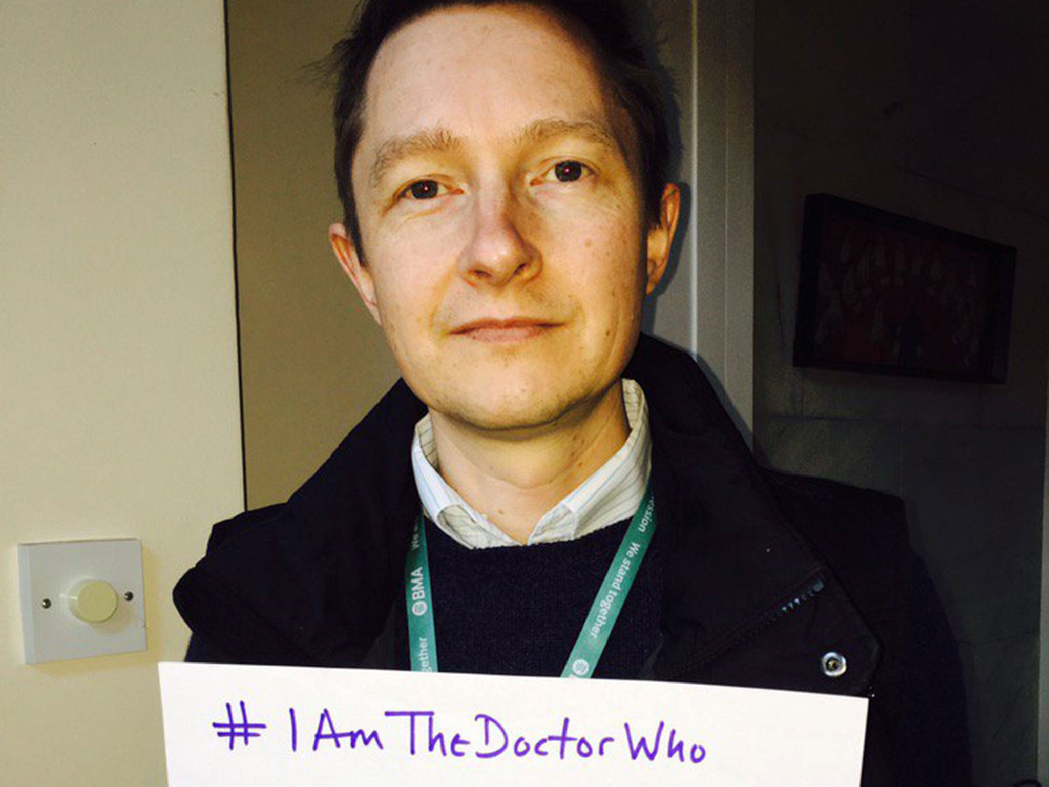 Dr Paul Watson holds a sign reading: '#IAmTheDoctorWho answered your questions when your child was admitted to intensive care '