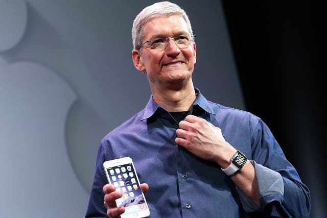 Apple CEO Tim Cook, proudly holding an iPhone 6
