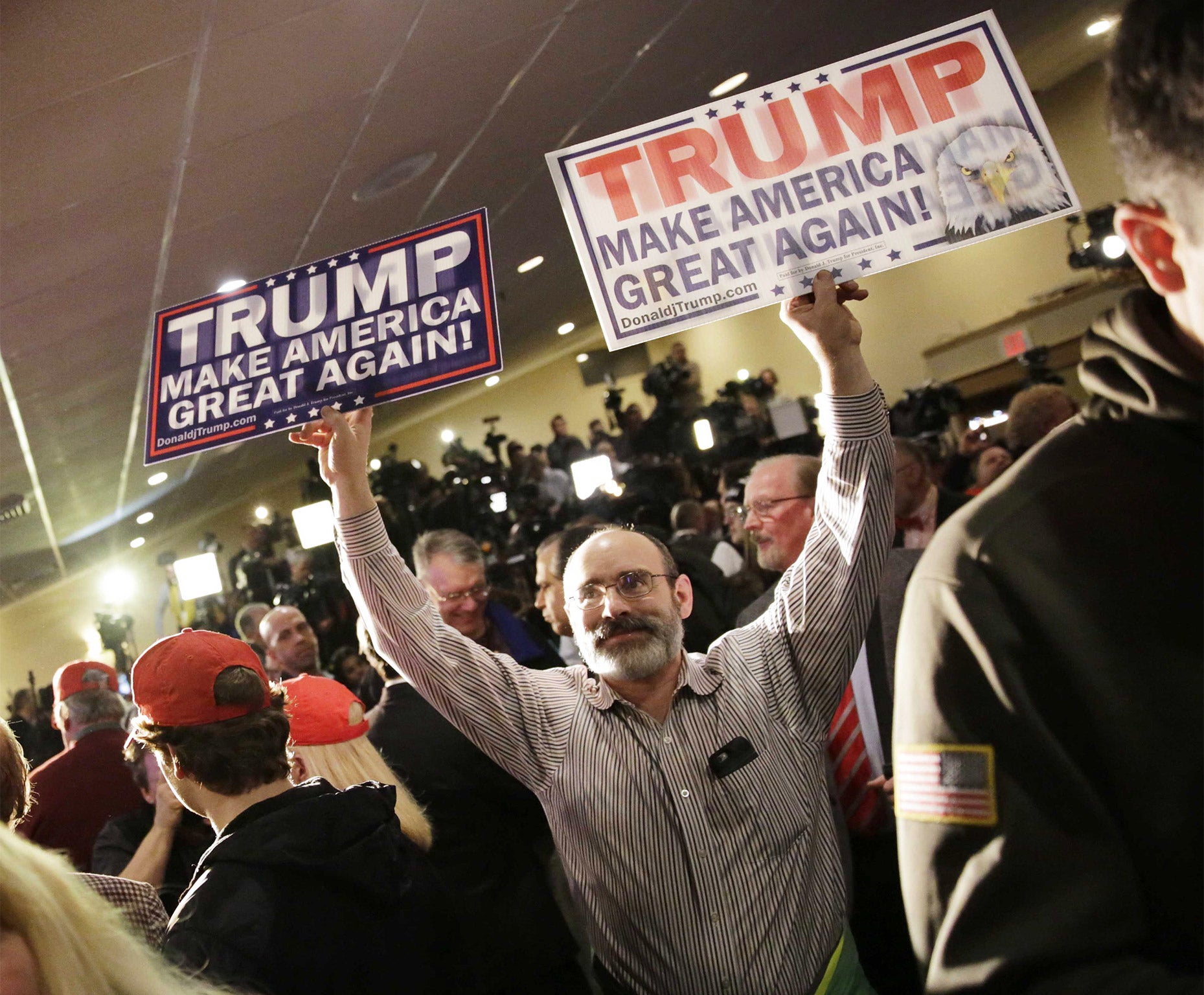 A Donald Trump supporter waves banners at the business tycoon's rally in Manchester, New Hampshire