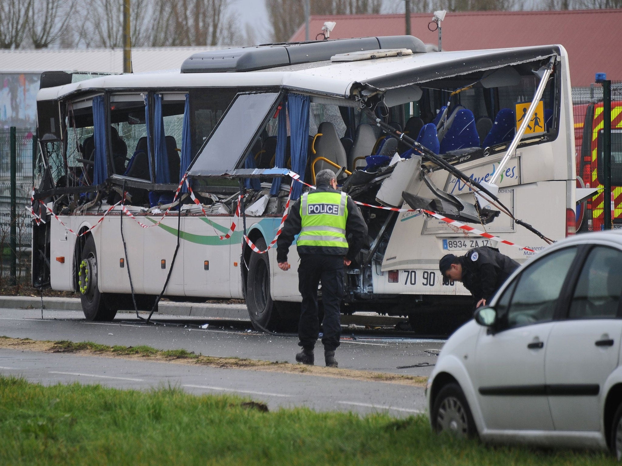 French police work near the wreckage of the school bus