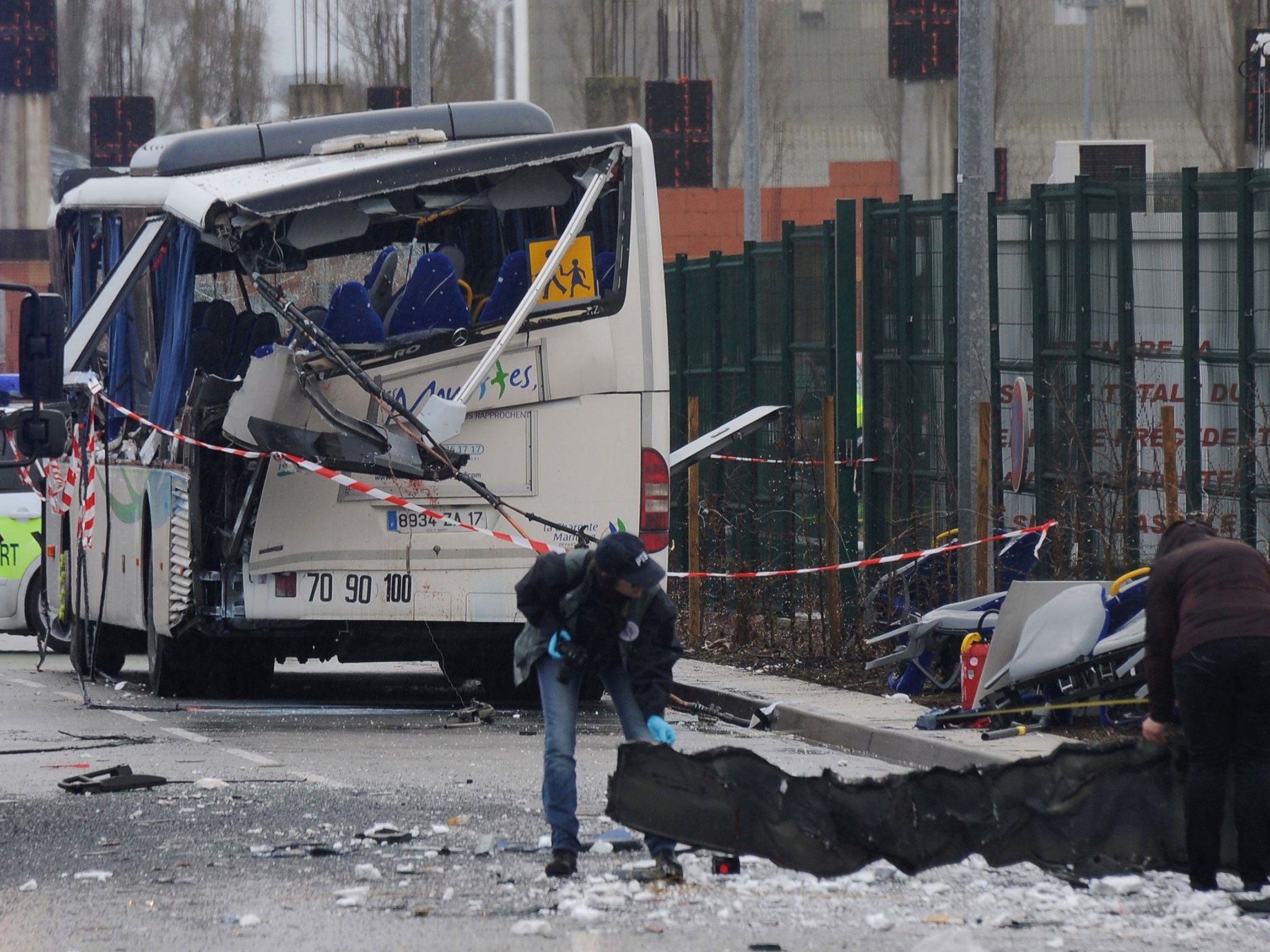 French forensic police work near the wreckage of a school minibus after it crashed into a truck near Rochefort on February 11