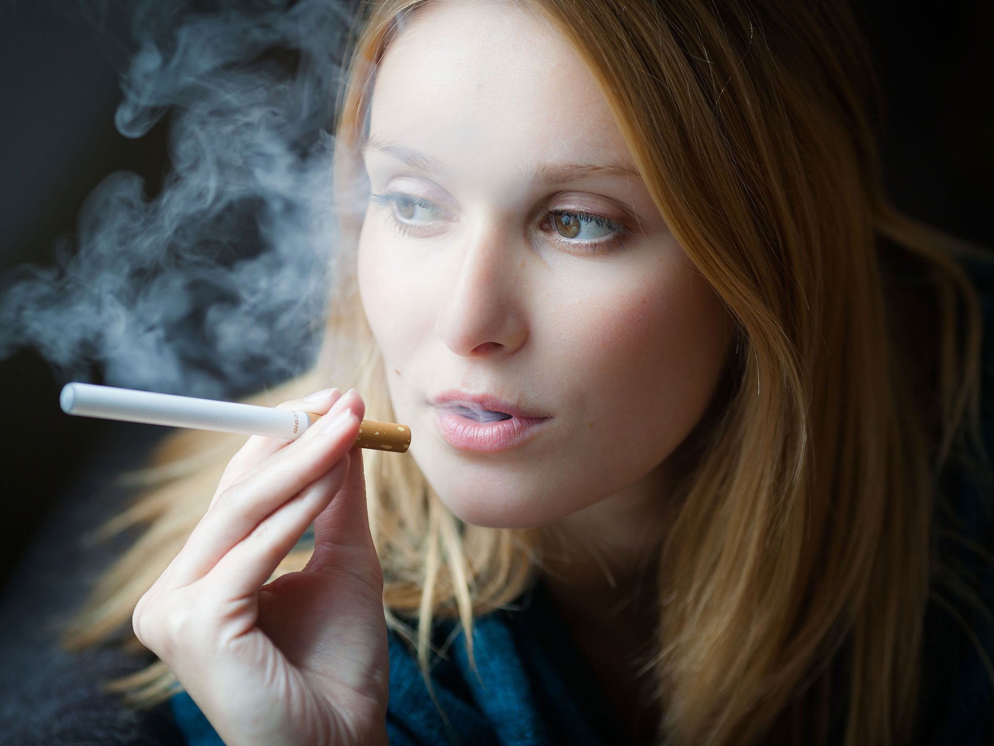 A woman smokes an e-cigarette