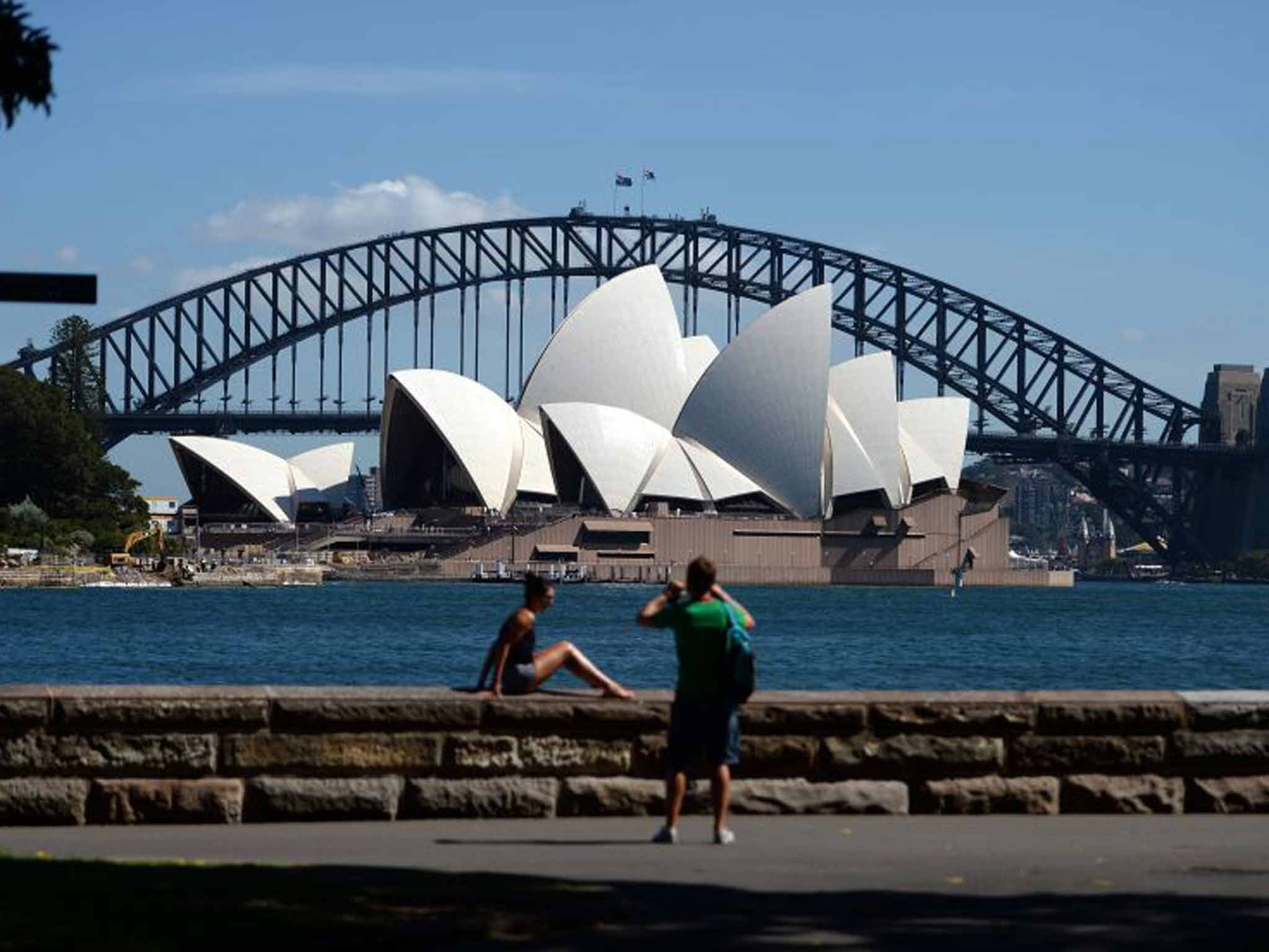 Tourists pose in front of the Sydney Opera House, Australia