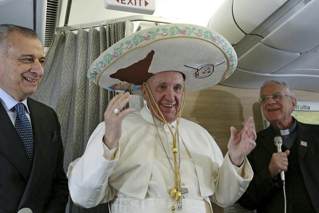 Pope Francis wears a Sombrero hat he received as a gift by a Mexican journalist aboard an airplane to Havana, February 12, 2016.