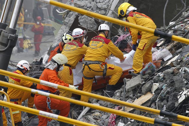 Rescuers pull a dead body from the wreckage