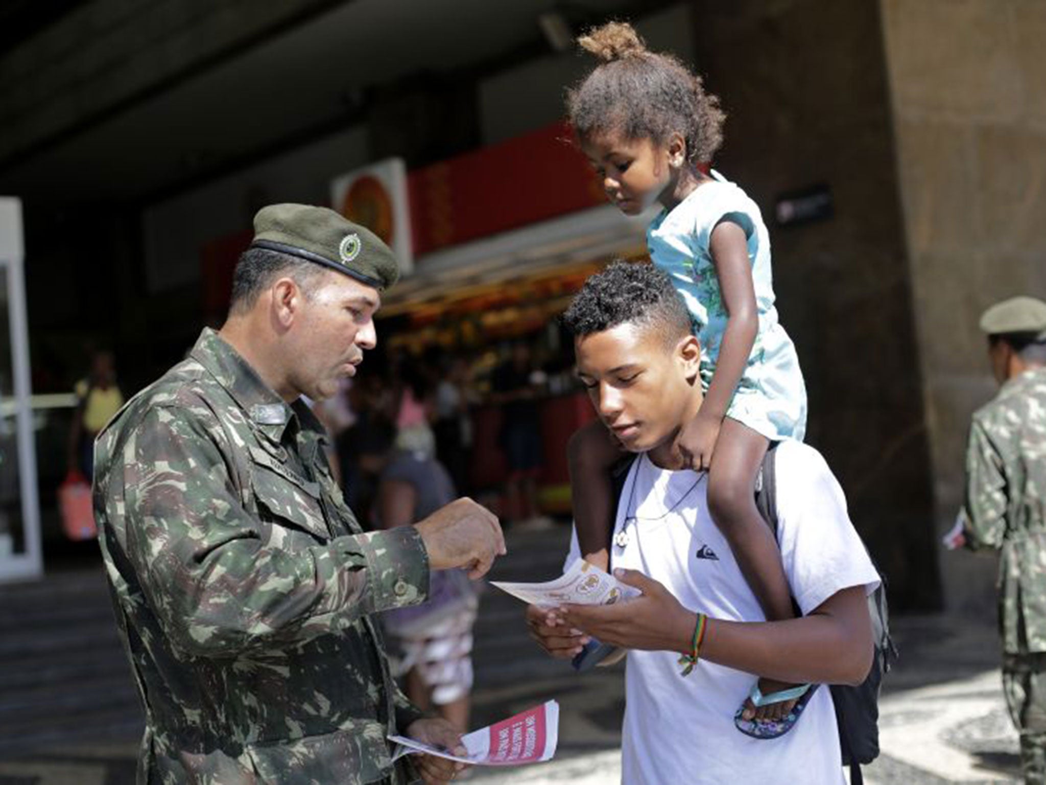 Members of the armed forces hand out leaflets on the Zika virus