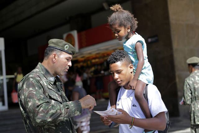 Members of the armed forces hand out leaflets on the Zika virus