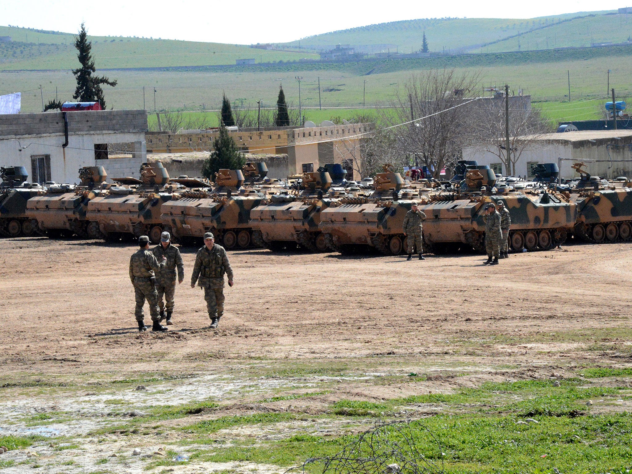 Turkish Army vehicles and tanks wait near the Syrian border