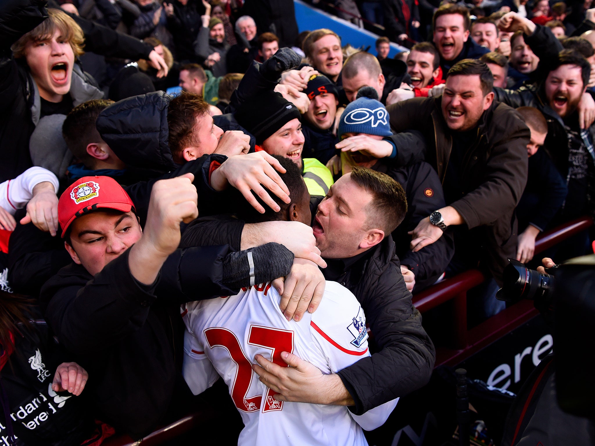 Divock Origi is embraced by an amorous Liverpool fan