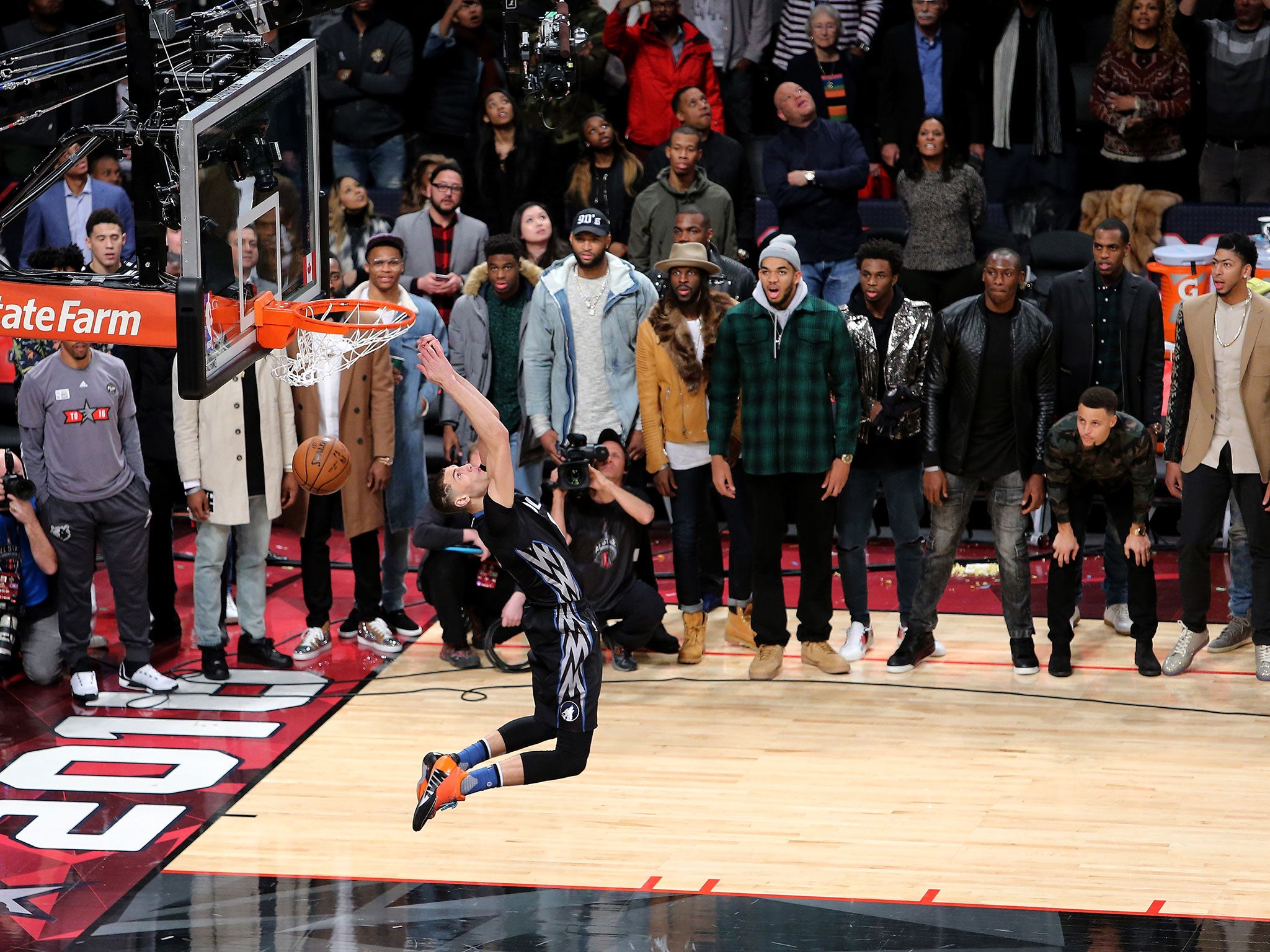 Zach LaVine of the Minnesota Timberwolves dunks as NBA players look on in the Verizon Slam Dunk Contest during NBA All-Star Weekend
