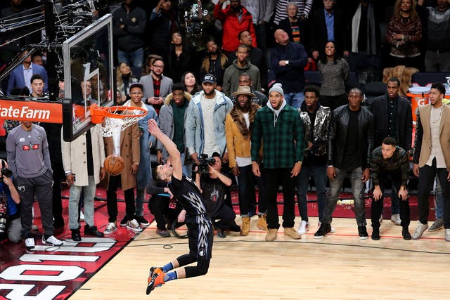 Zach LaVine of the Minnesota Timberwolves dunks as NBA players look on in the Verizon Slam Dunk Contest during NBA All-Star Weekend