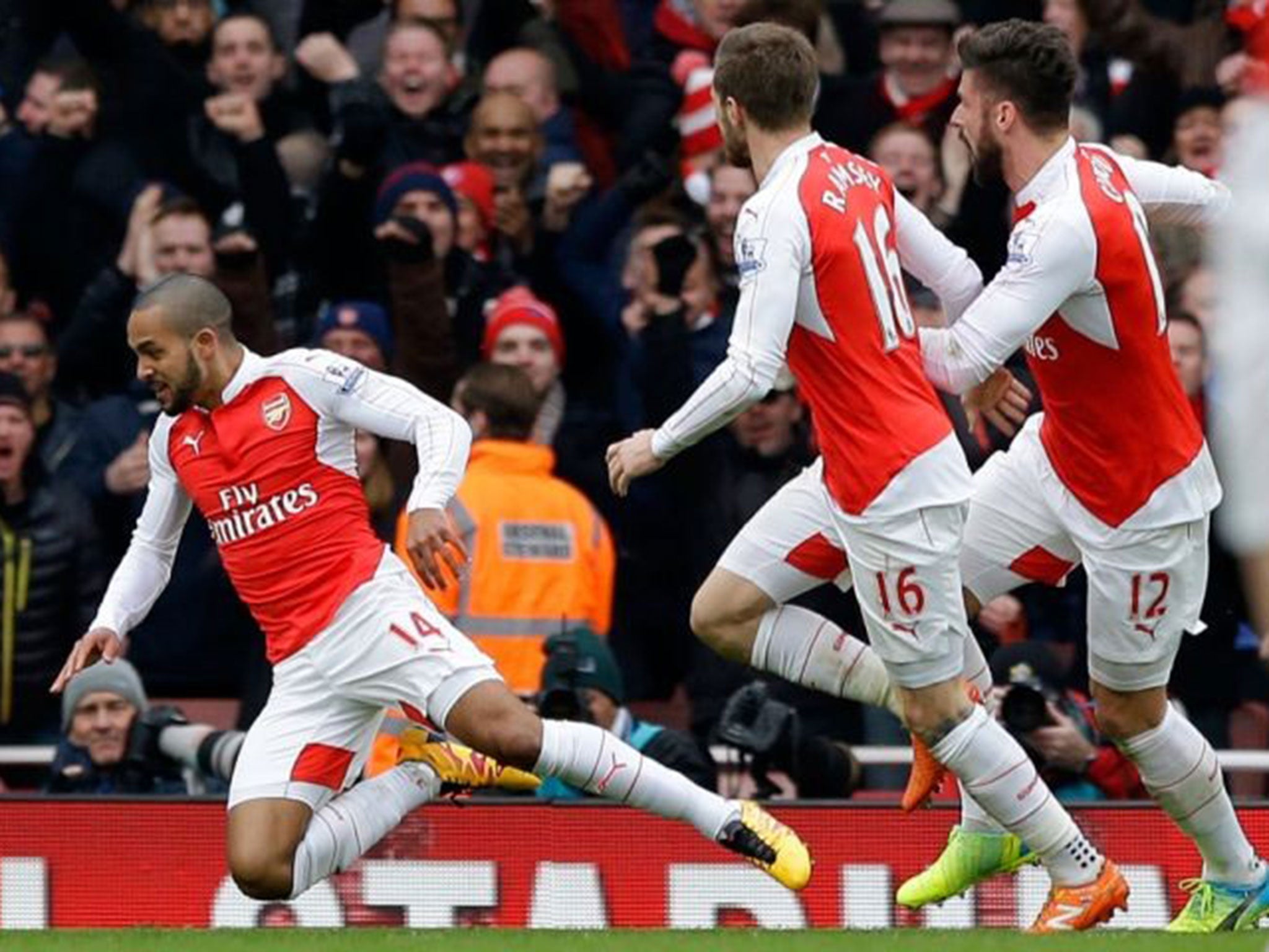 Theo Walcott is thrown to the ground by Olivier Giroud in celebration after his goal for Arsenal