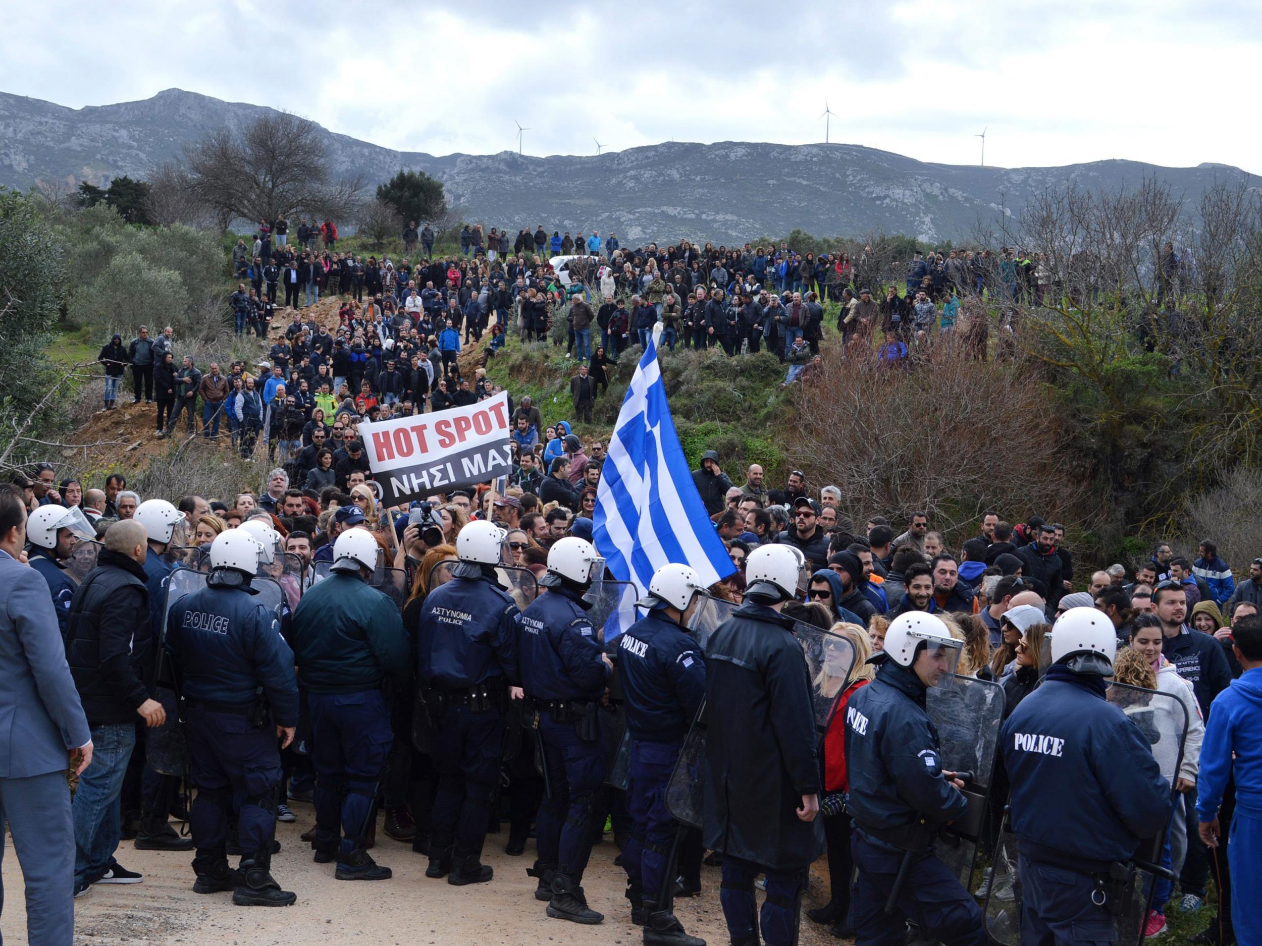 Protesters hold banners and greek flags during a demonstration on the island of Kos, in the Eastern Aegean, against the creation of an identification and registration centre for refugees and migrants who are entering the European Union through Greece